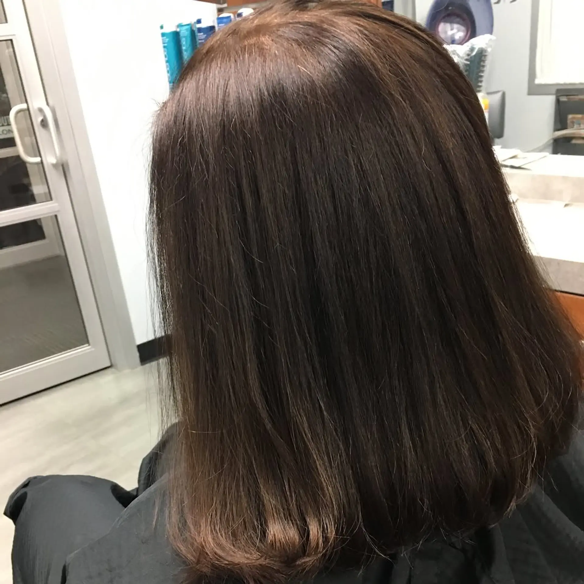 A sleek, smooth medium-length blowout with soft inward-curved ends in a rich dark brown tone. 1
