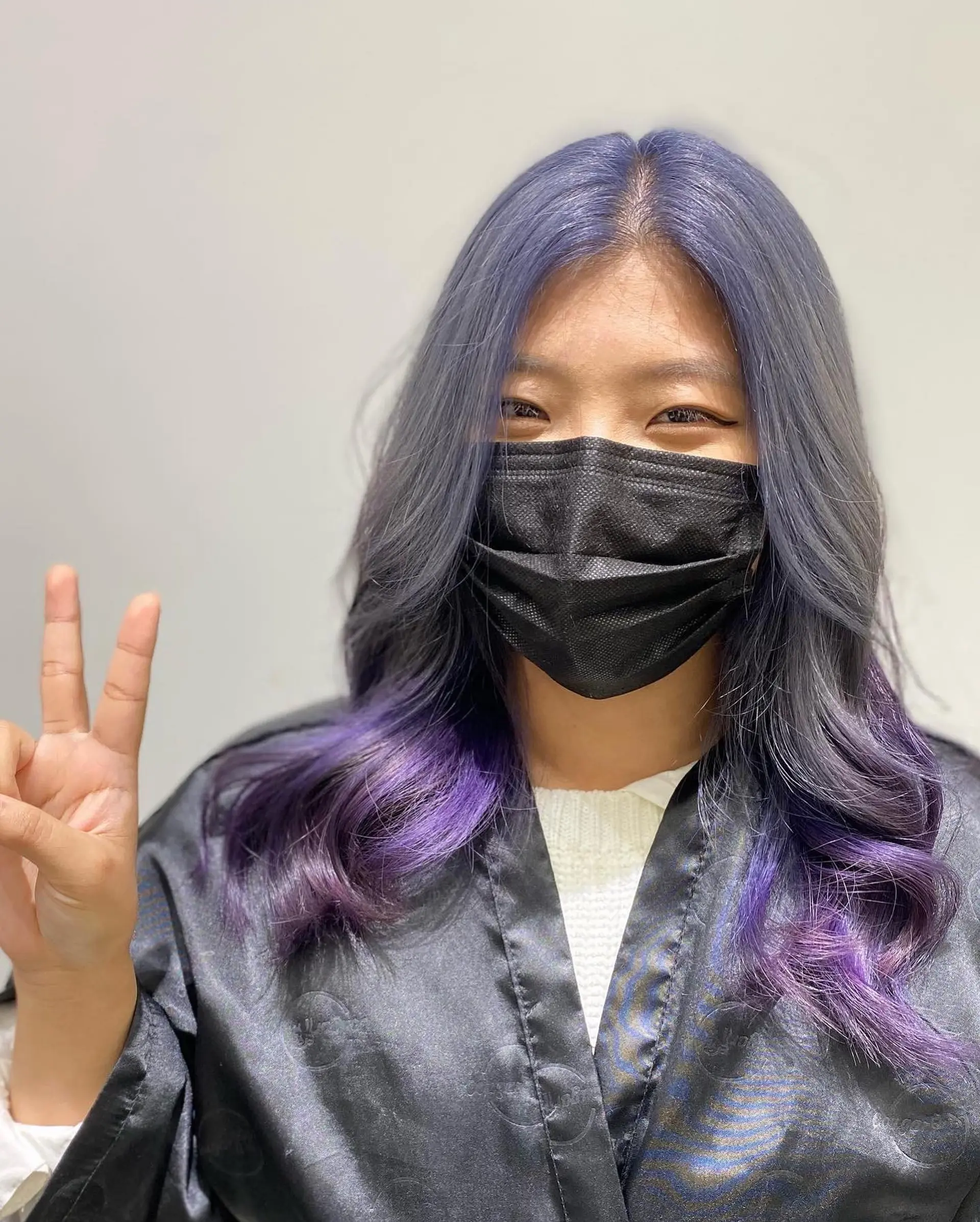 Long, wavy hairstyle with lavender roots that blend into purple ends. 1