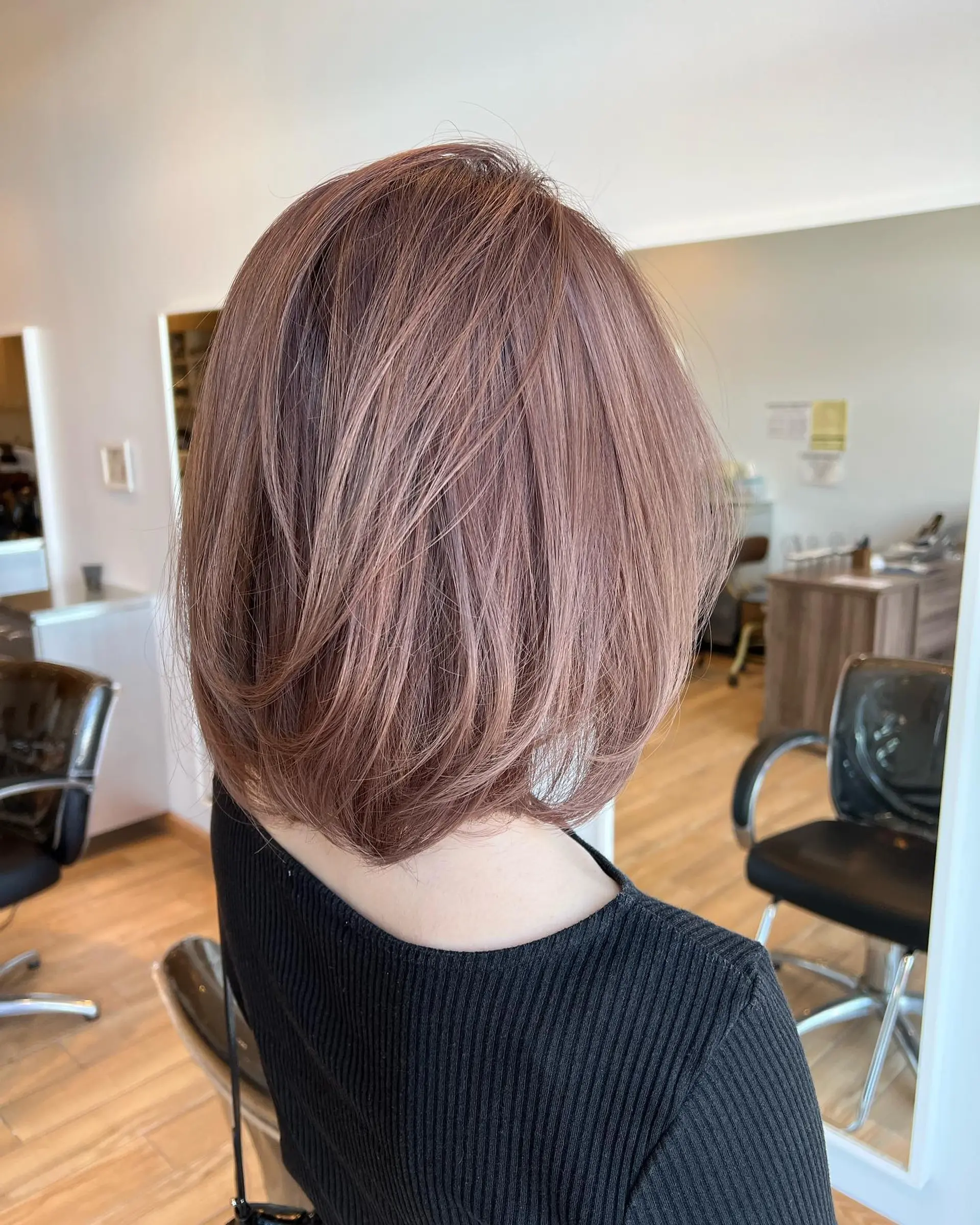A soft, voluminous layered bob styled with curved ends in a dimensional milk tea tone. 1
