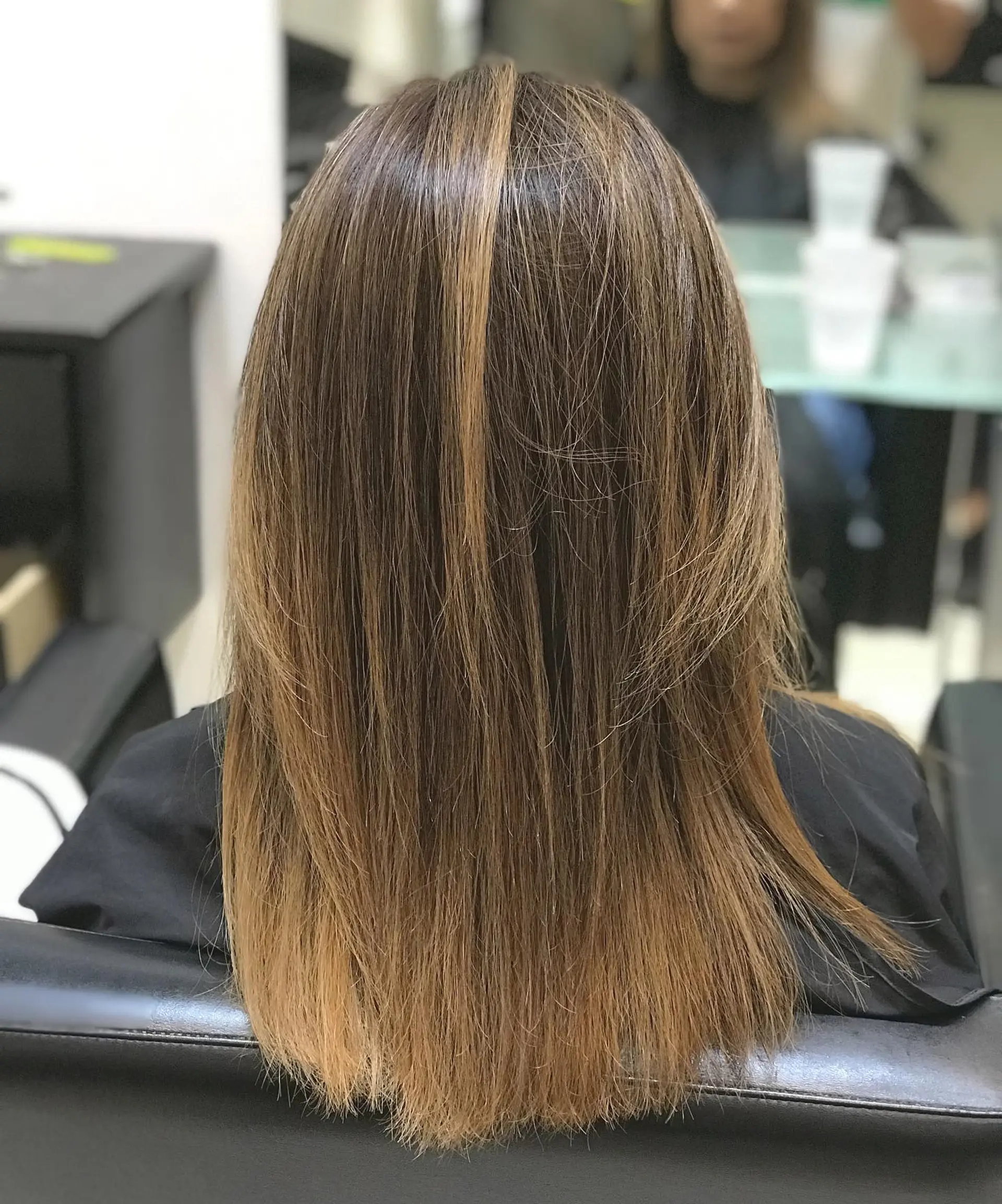 Long, straight brunette hair with blonde balayage highlights and subtle layers. 1