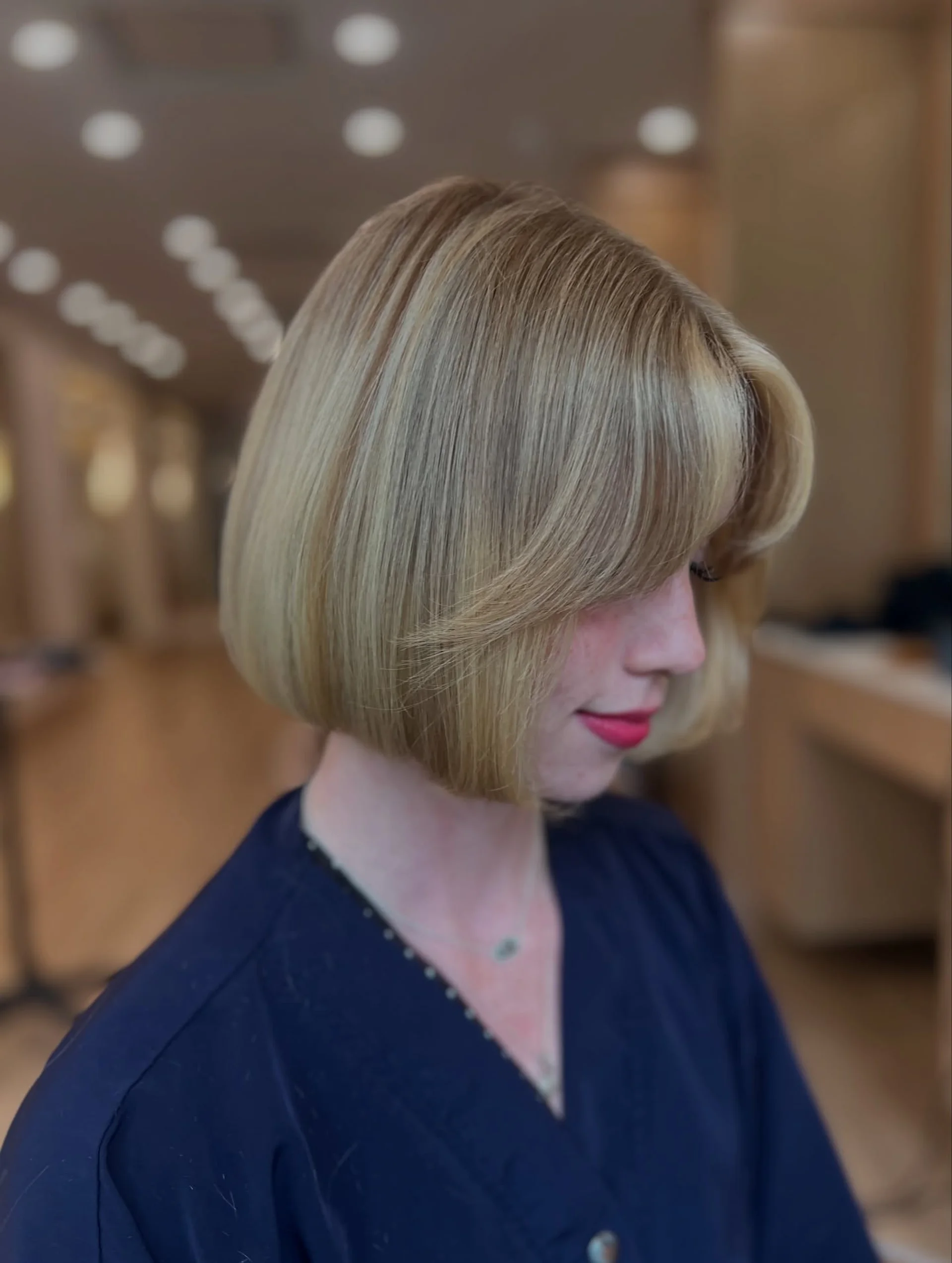 A woman with a chic square bob and elegant curtain bangs, showcasing a modern and sophisticated hairstyle. - Preview 2