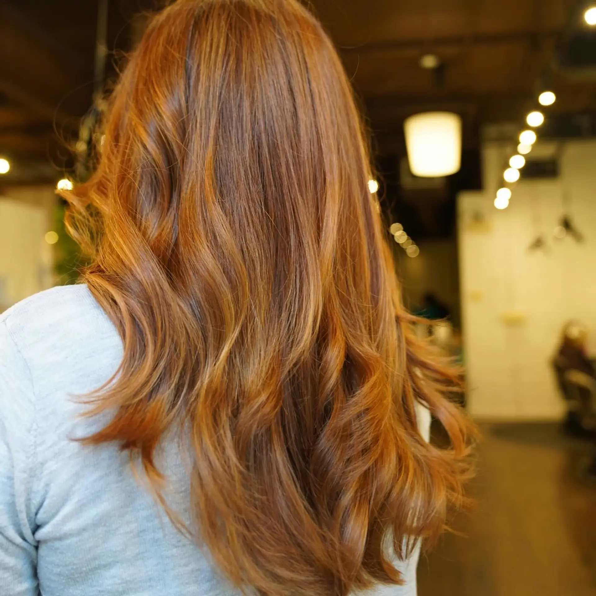 Long, layered wavy hairstyle with copper and auburn balayage highlights. 1