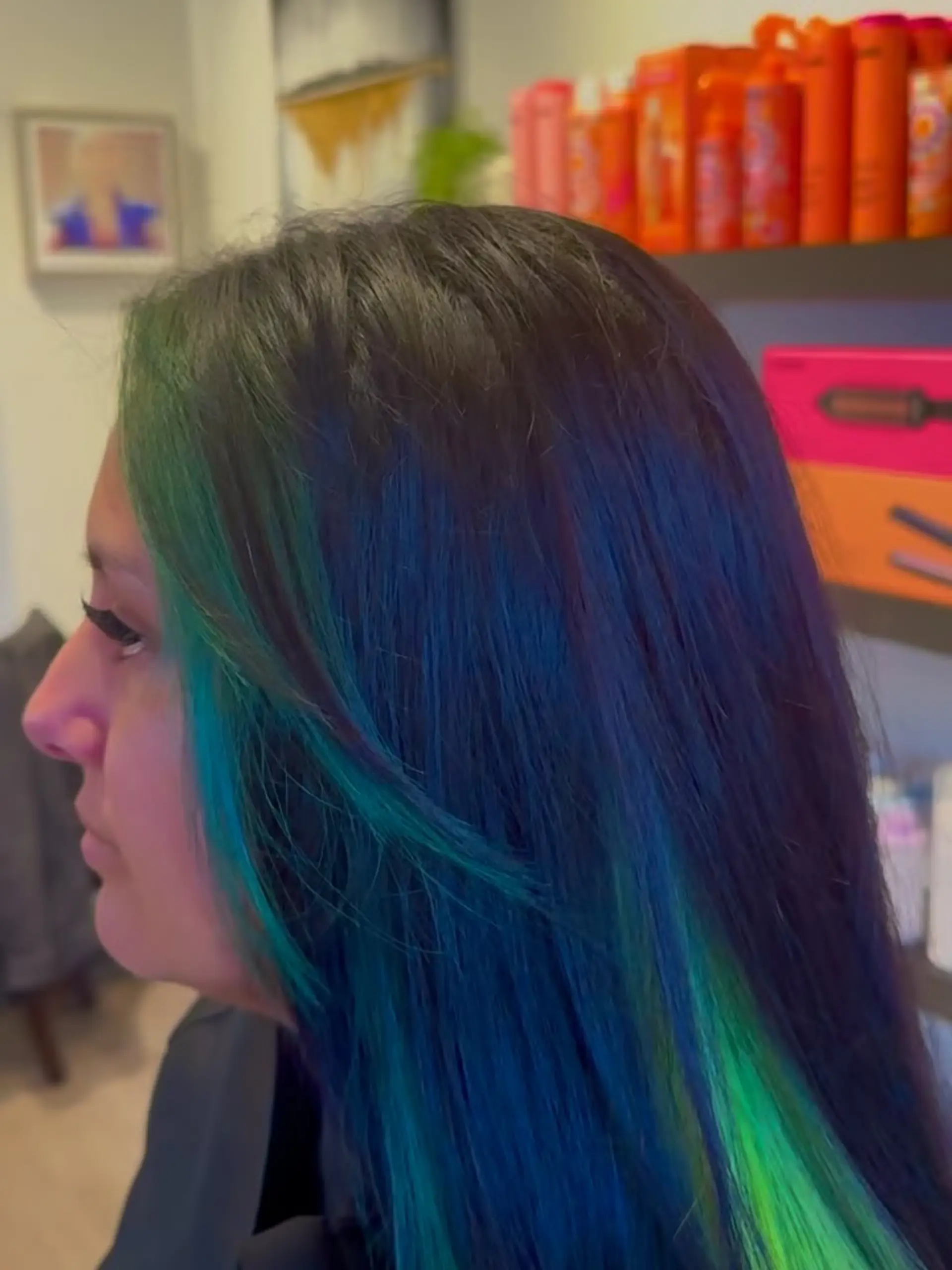 Straight dark hair styled with vibrant emerald and teal green money piece face-framing highlights. 1