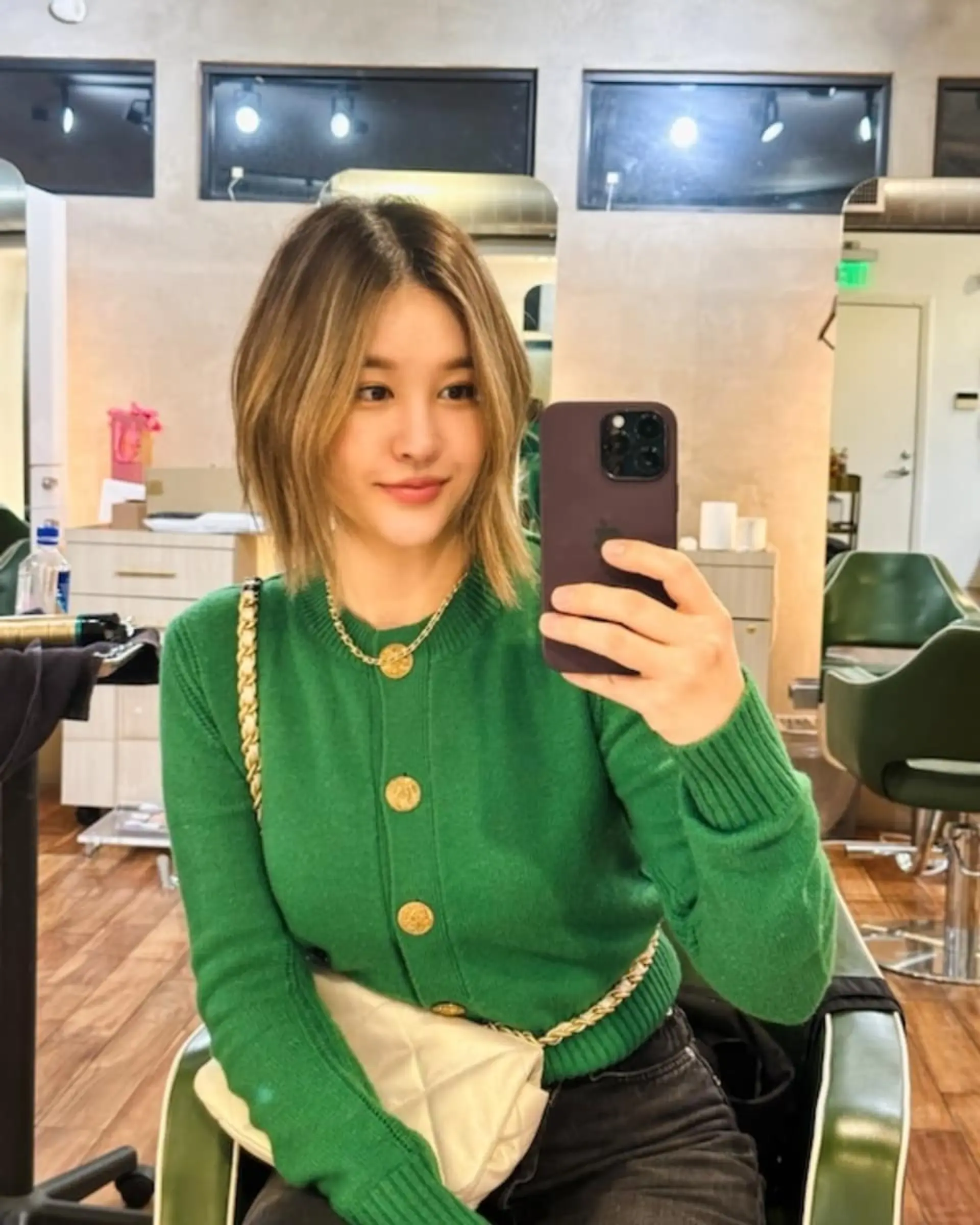 A textured A-line bob cut styled with a center part and soft, face-framing golden blonde highlights. 1