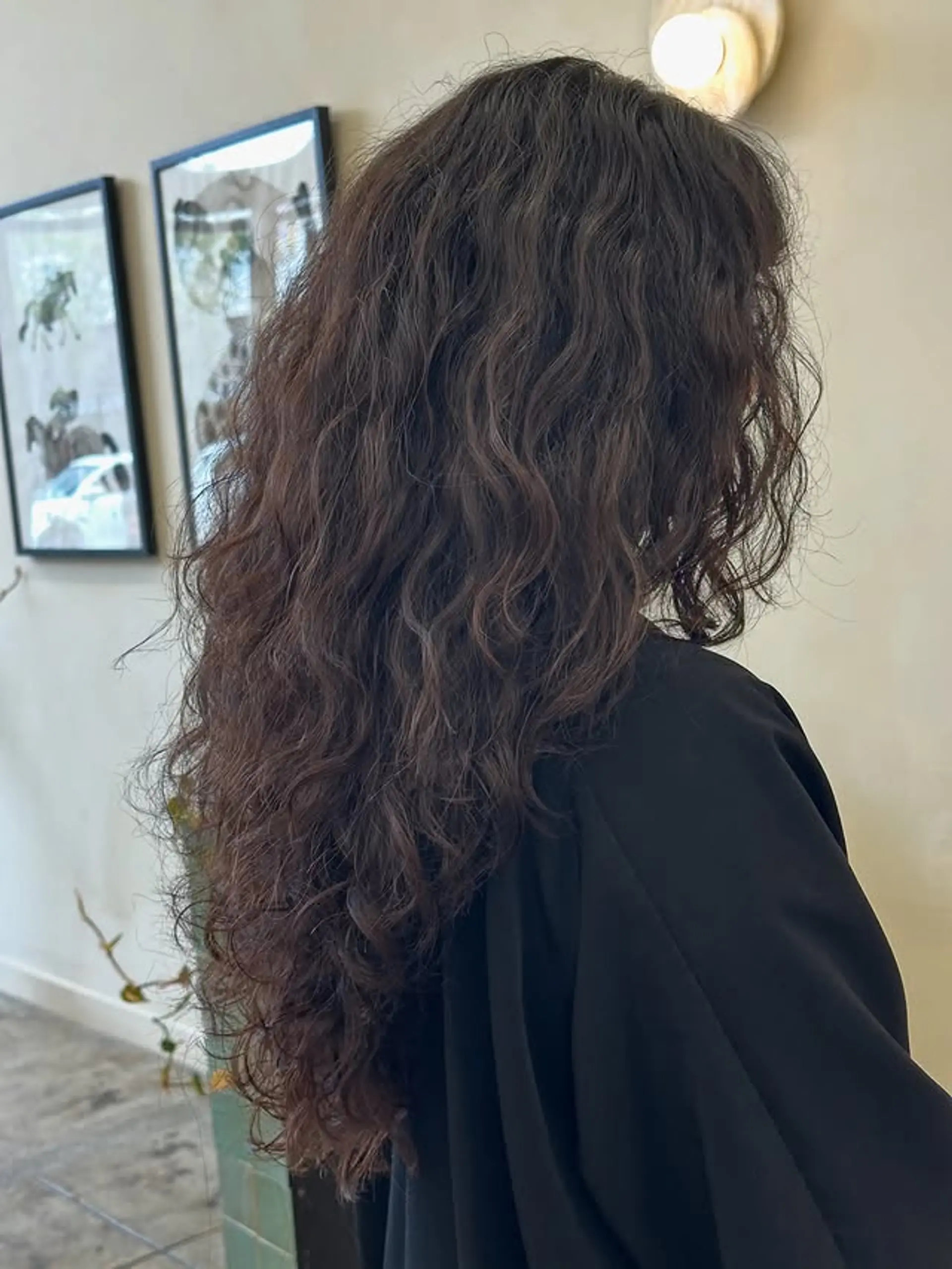 Long, wavy hair with natural brunette tones. 1