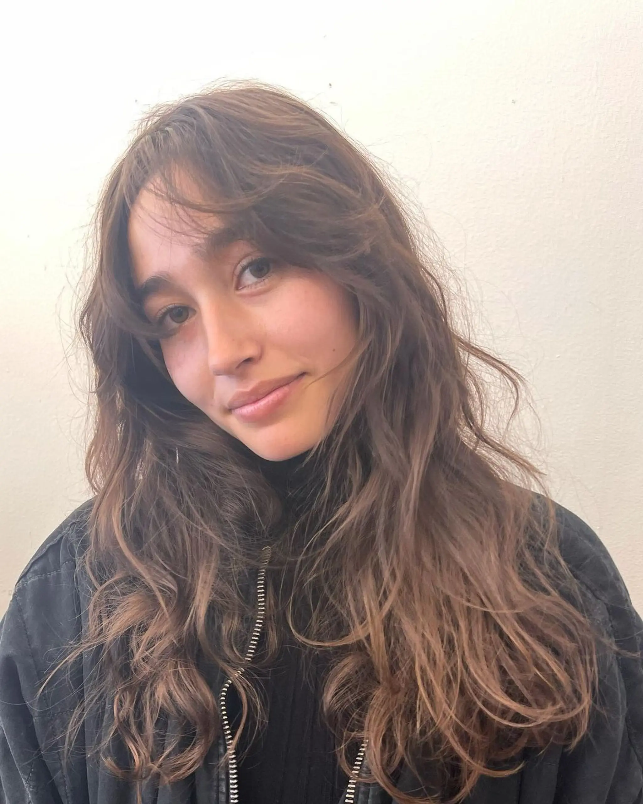 Long, wavy brown hair with natural highlights, featuring messy waves, soft layers, and face-framing tendrils. 2