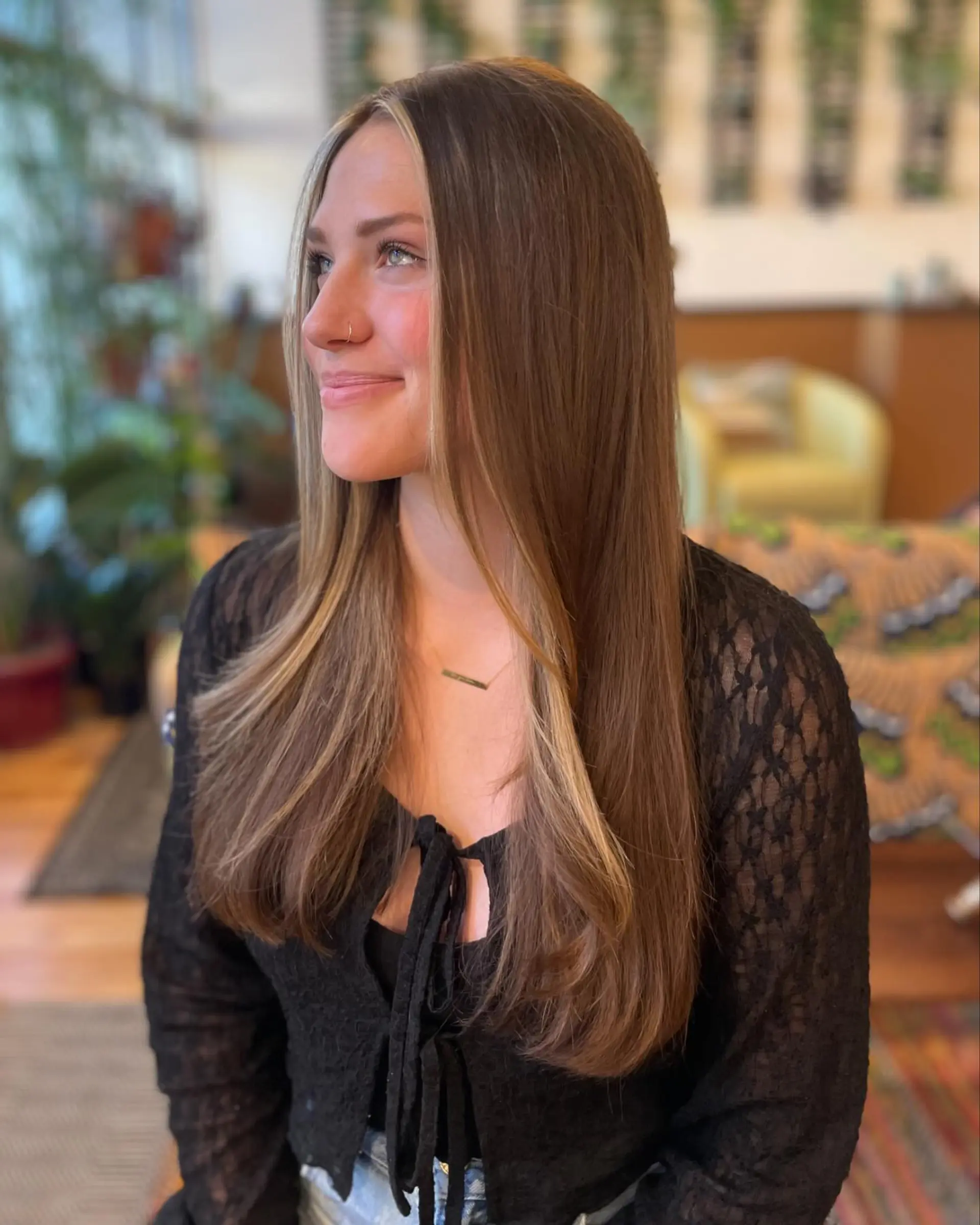 Straight, smooth long brunette hair featuring long layers and a bright blonde face-framing money piece. 1