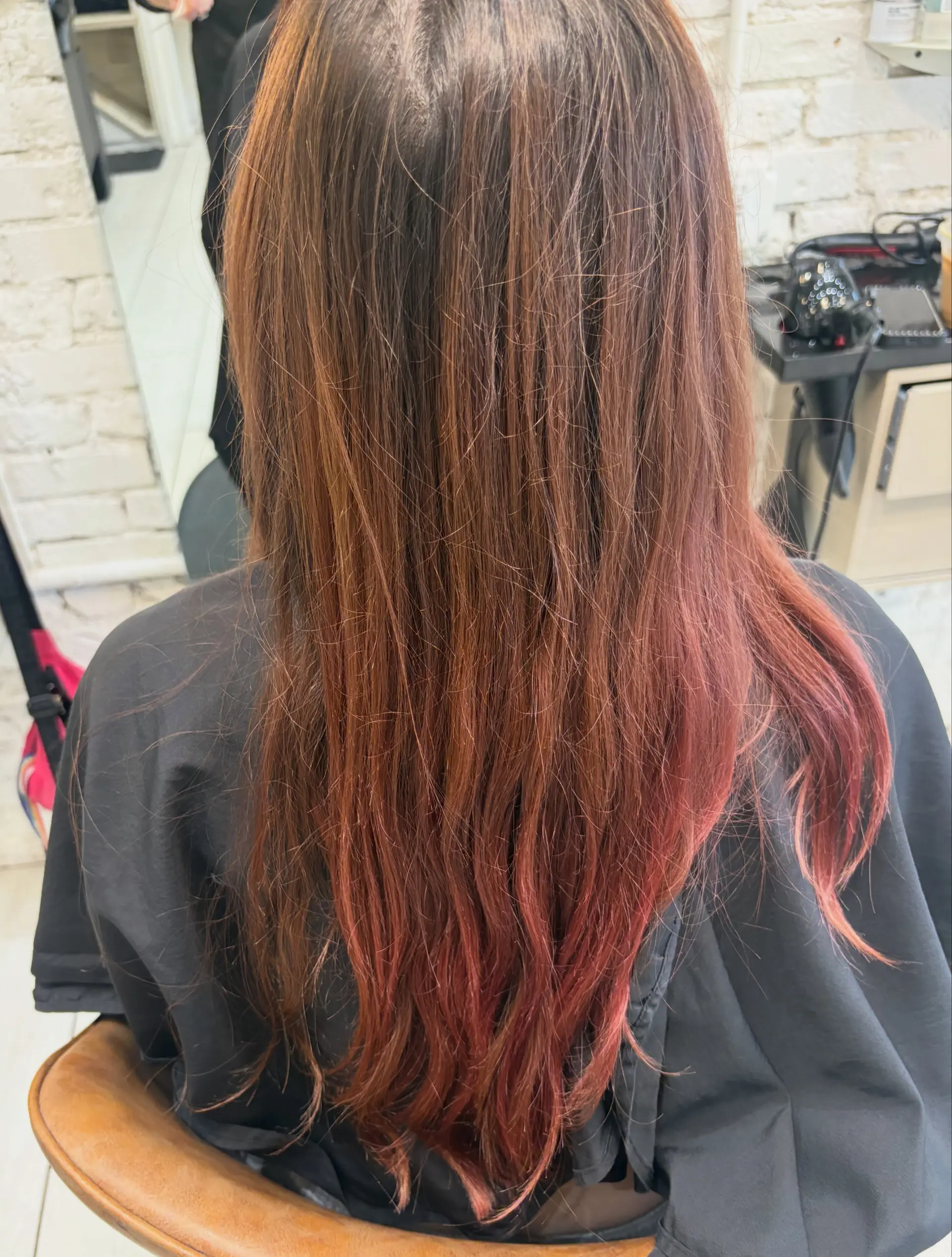 Long hair featuring a rich brunette base transitioning into soft, muted pink ends. 1
