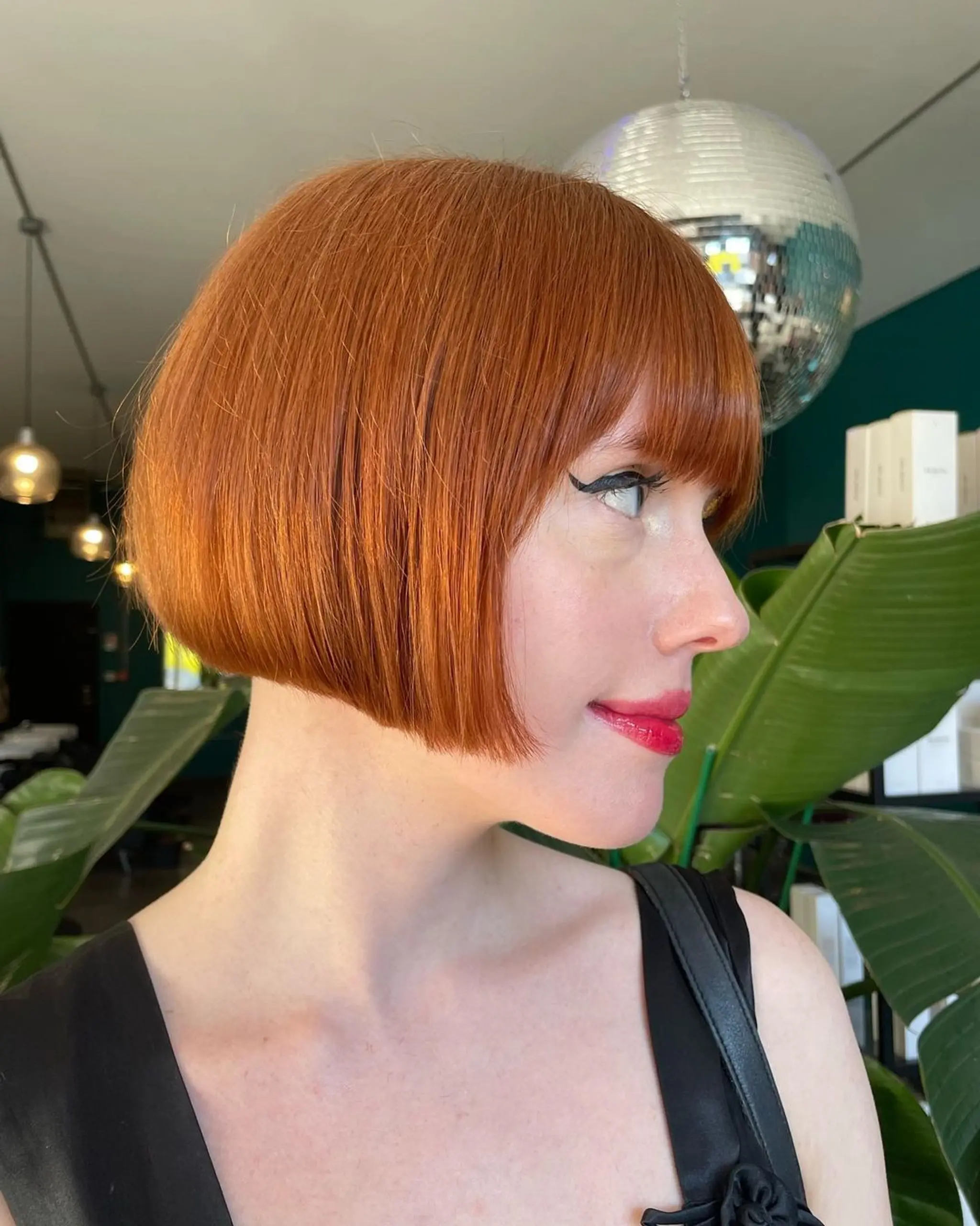 Chic auburn bob with straight, short hair featuring fringe bangs and a sleek, warm-toned finish. 2