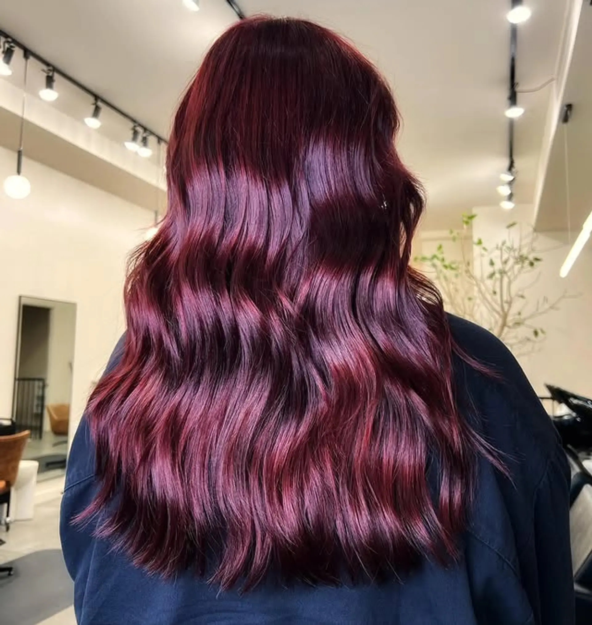 Long, wavy hair styled in a vibrant burgundy color. 1