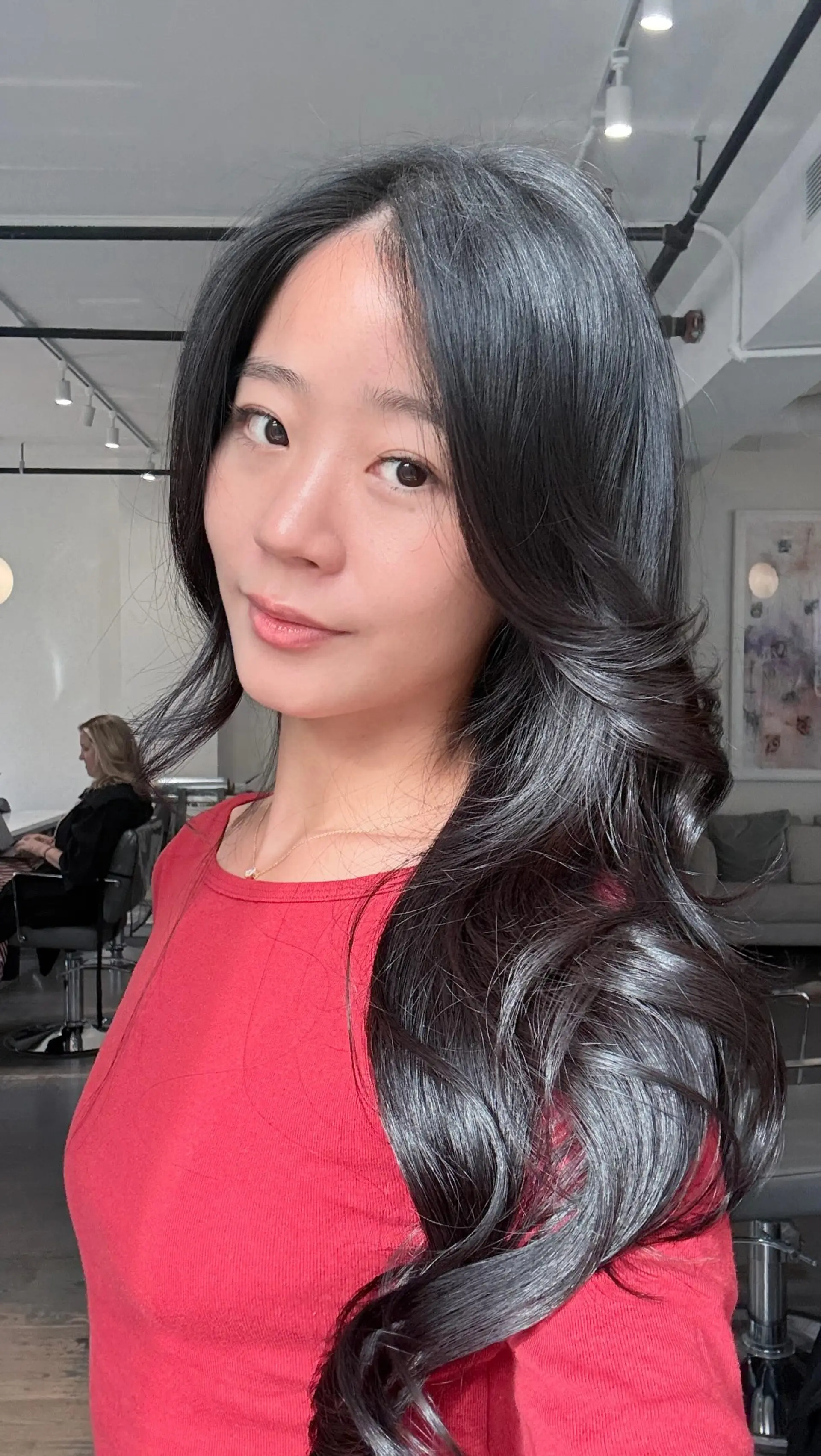 Long, glossy black hair styled in voluminous blowout waves with face-framing layers. 1