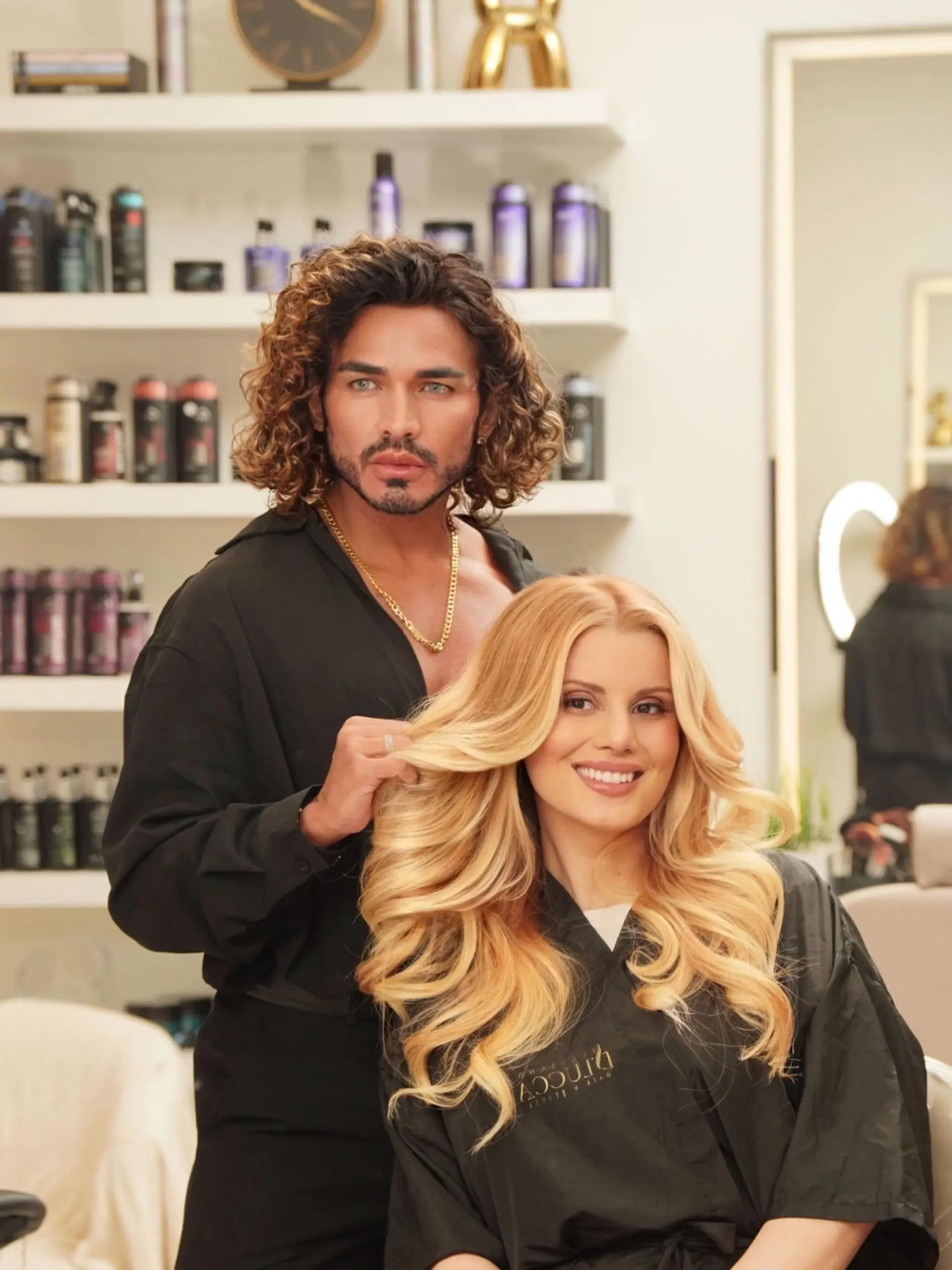 Long golden blonde hair styled in polished, voluminous cascading waves. 1
