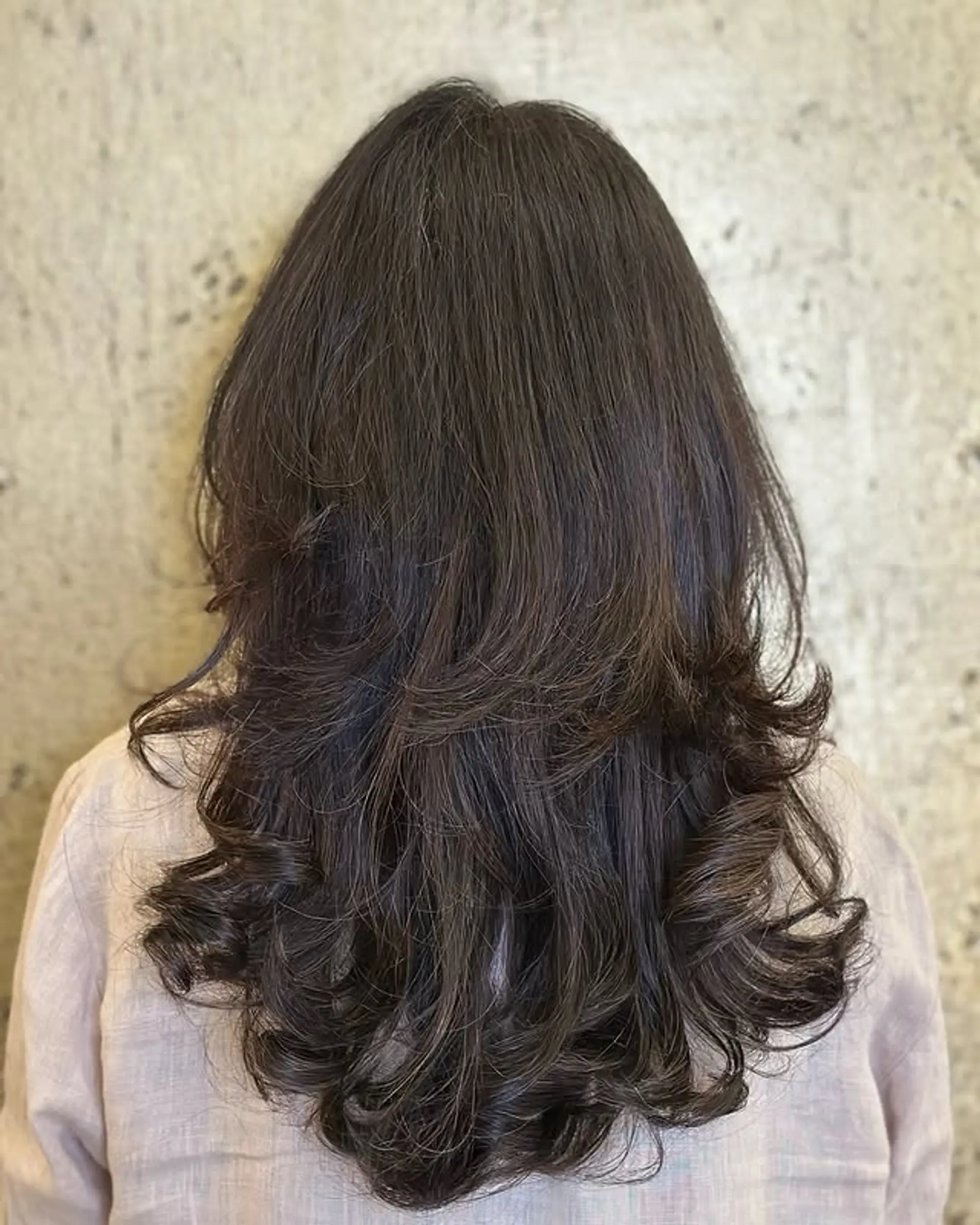 Long layered hairstyle with soft curls at the ends. 1