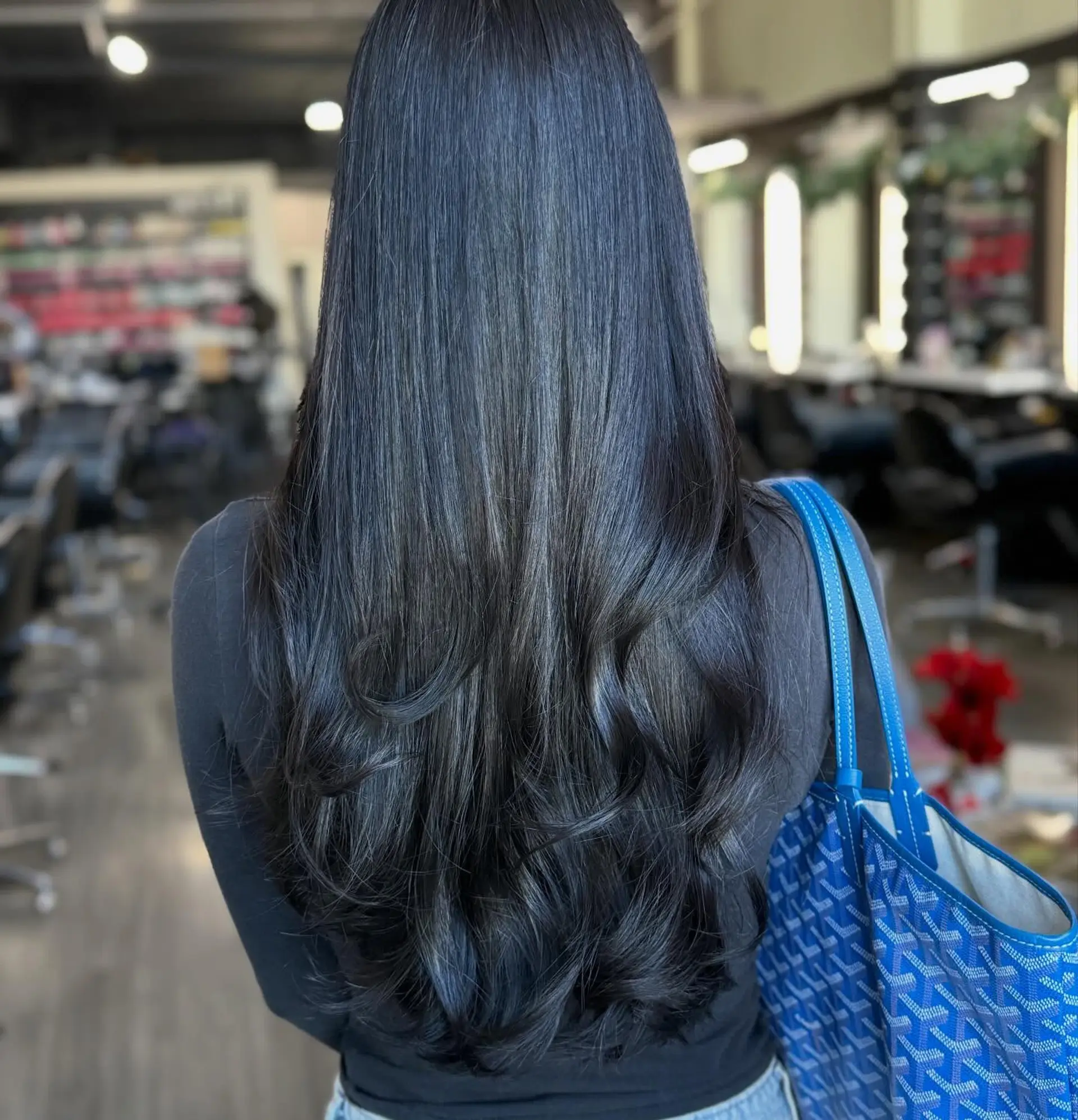 Extra-long, glossy black hair cut in soft flowing layers with flipped and curled ends. 1