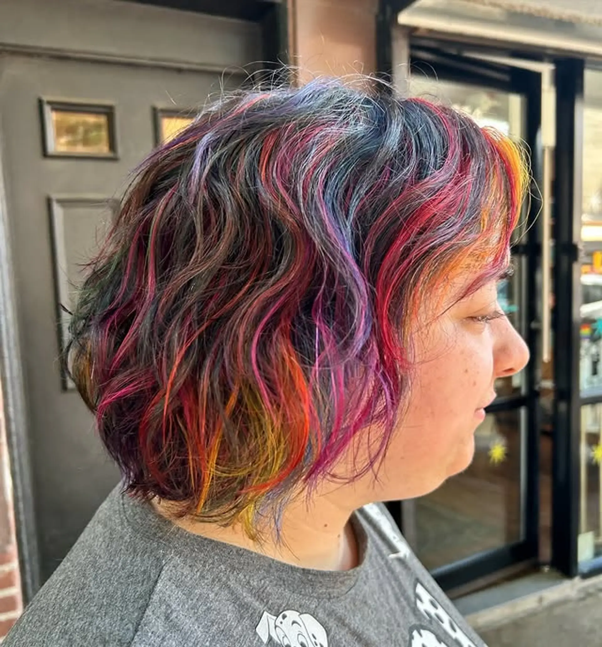 A vibrant, medium-length wavy bob with a multi-colored rainbow sherbet theme. 1