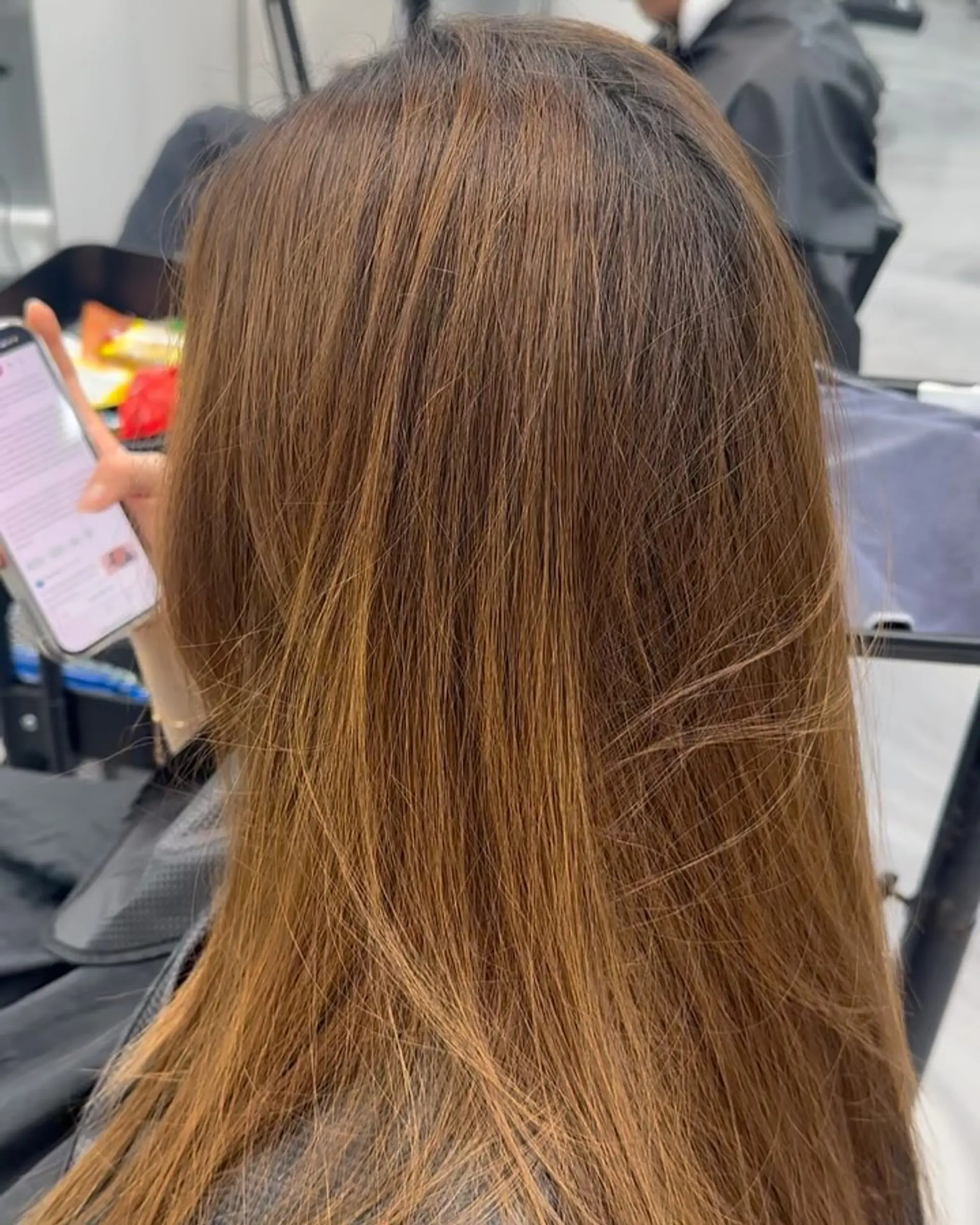 Long, straight hair colored in a natural warm chestnut light brown tone. 1