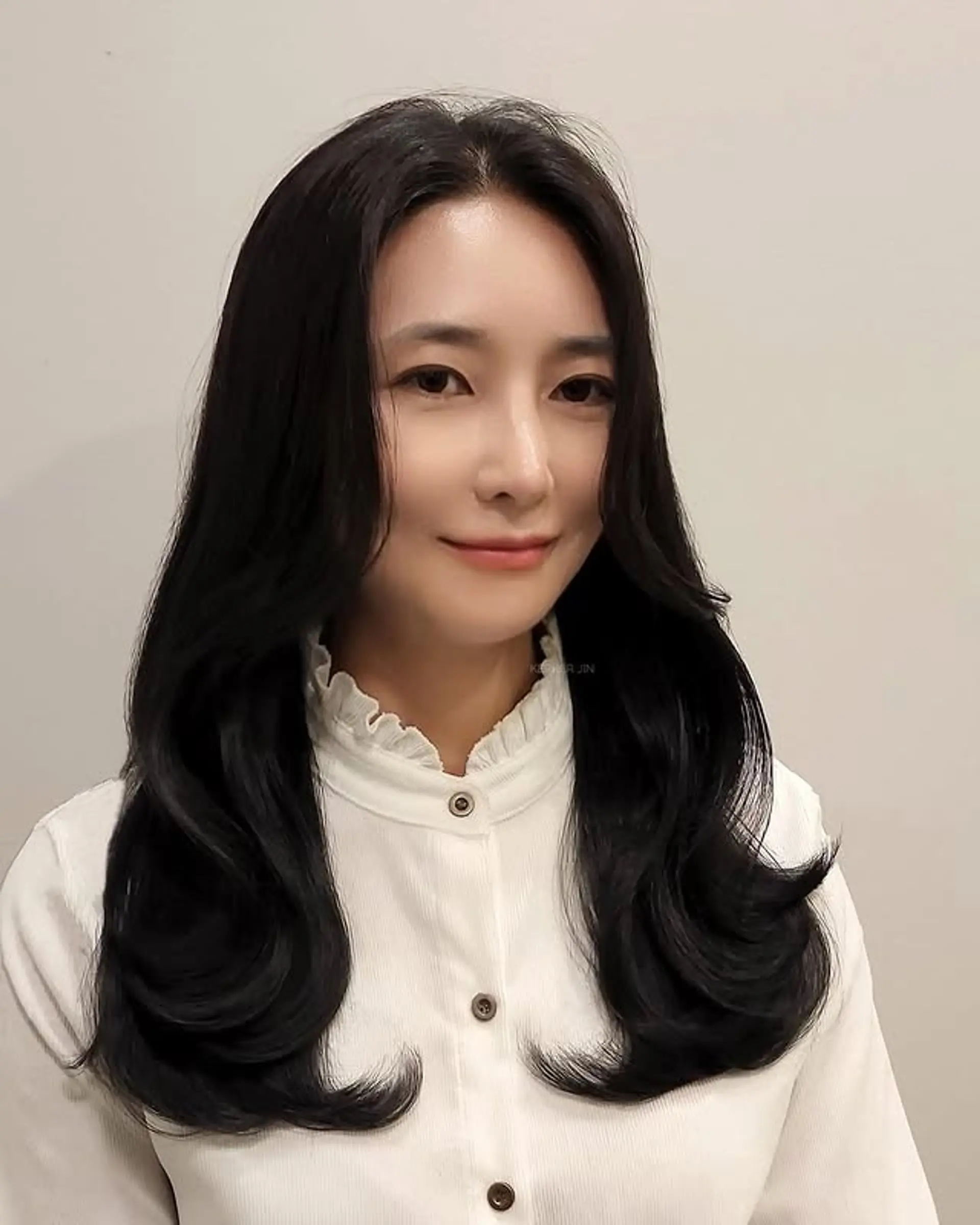 Long layered hair with a C curl perm and curtain bangs. 1