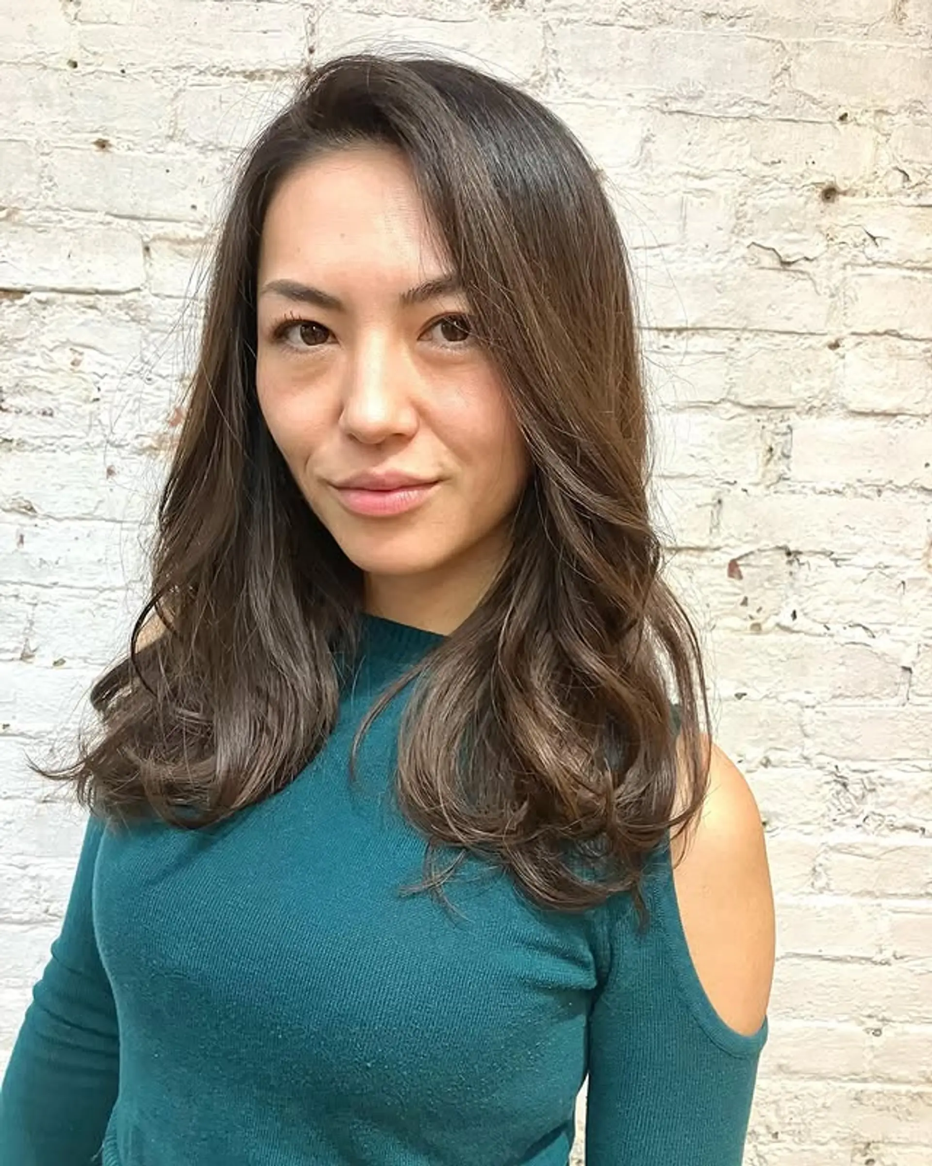 A medium-length layered haircut with soft, chocolate brown waves. 1
