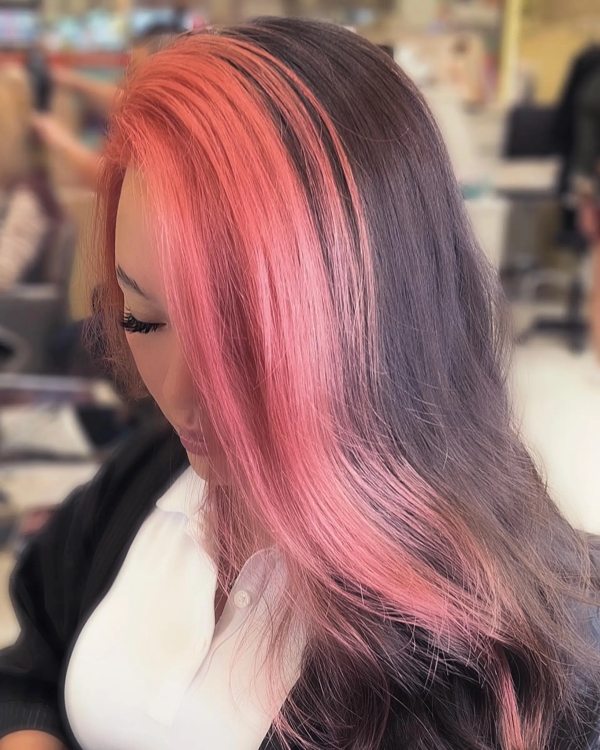A long, straight hairstyle featuring a split dye technique with one side pink and the other dark brown. 1