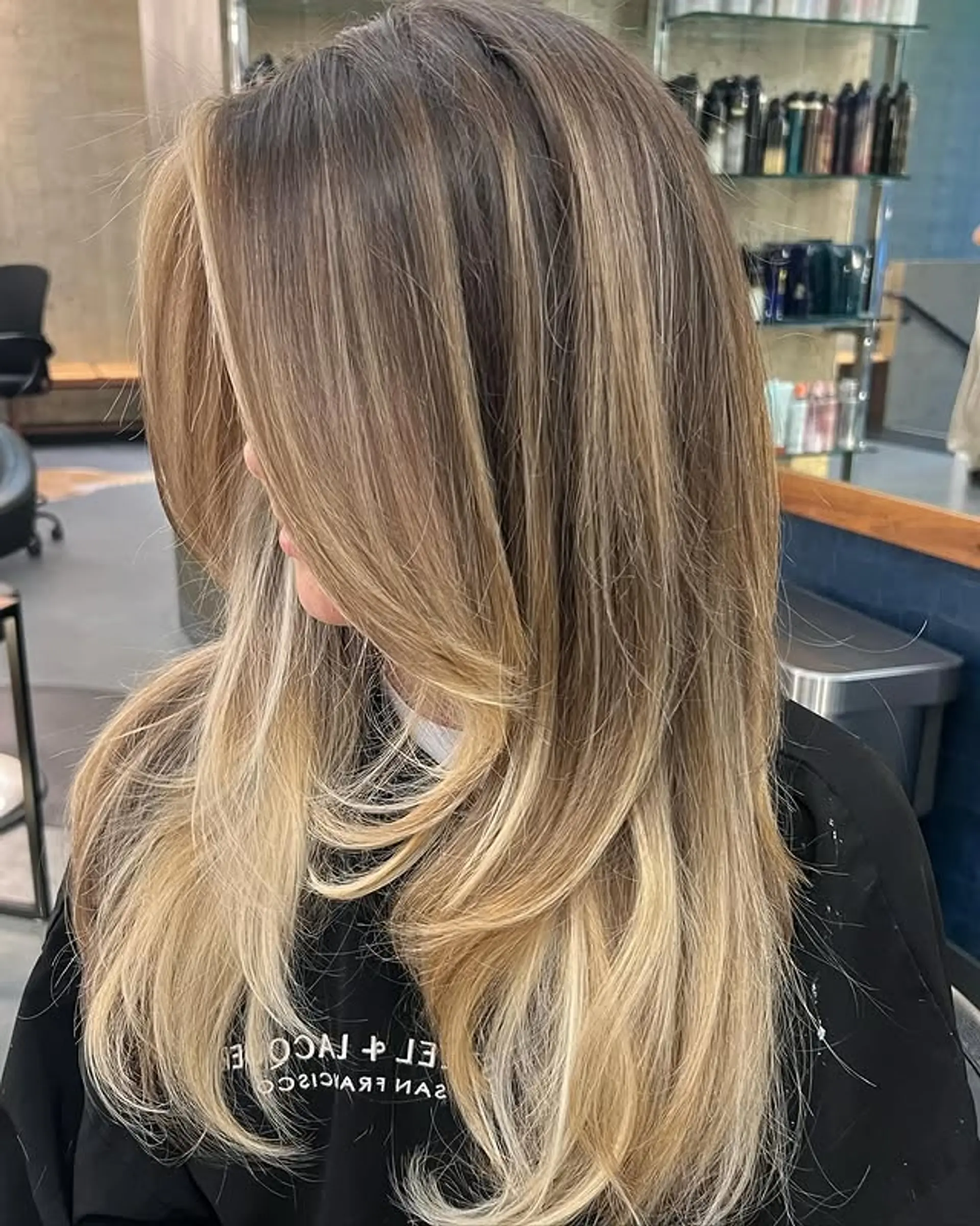 Long layered hairstyle with a seamless brunette to blonde balayage and face-framing layers. 1