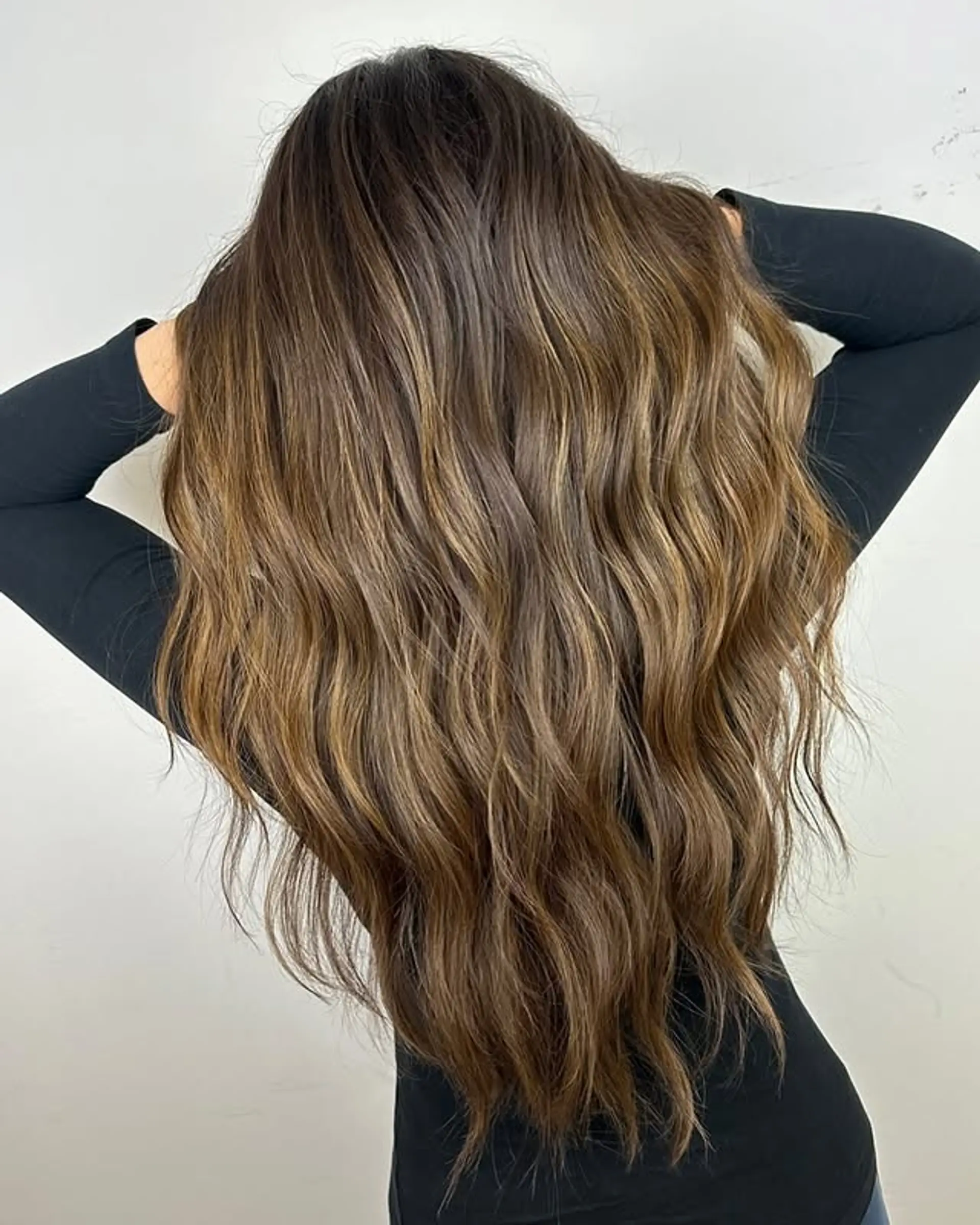 Long, wavy hair with a dimensional balayage in bronze and blonde tones. 1