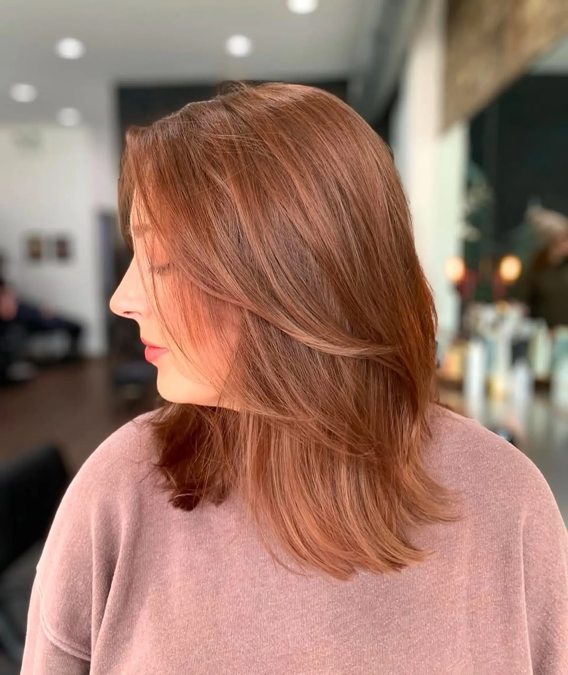 A modern medium-length lob featuring soft, face-framing layers and internal layering for enhanced movement and natural volume. The ends are styled with a gentle inward curve. 1