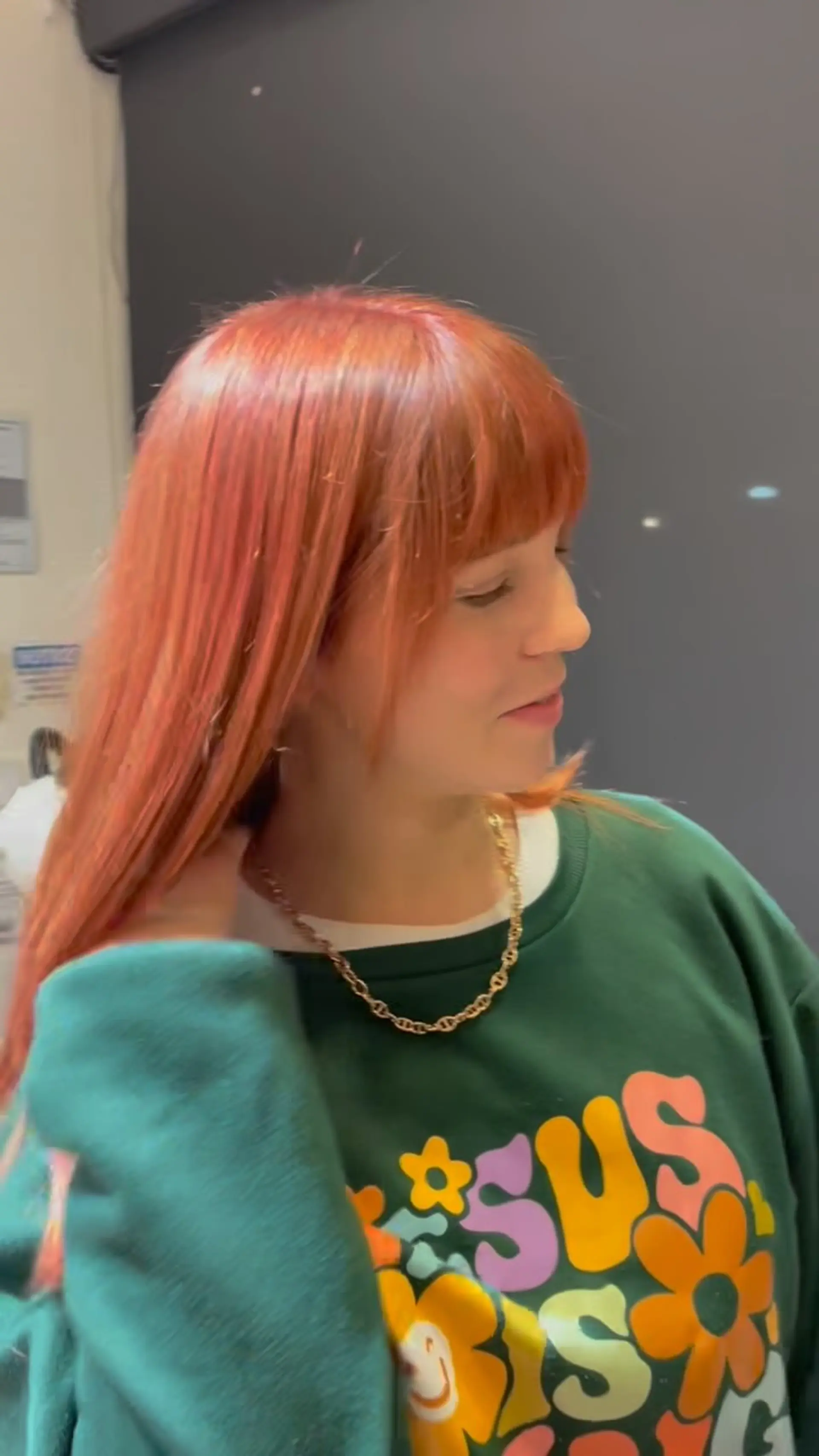 Straight medium-length hair colored in a glowing nectarine-peach tone featuring full front bangs. 1