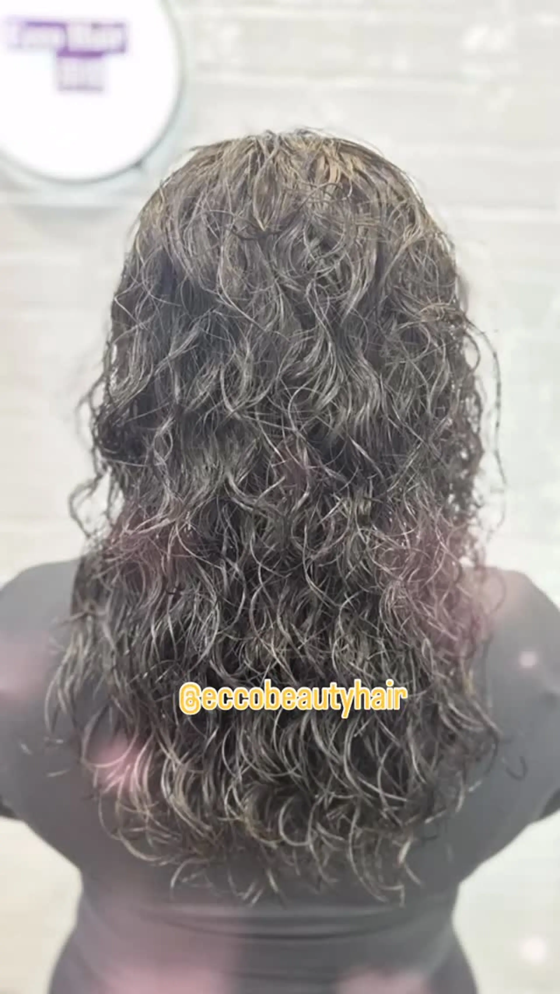 Long dark hair styled with defined, tight curls featuring a glossy, wet-look texture. 1