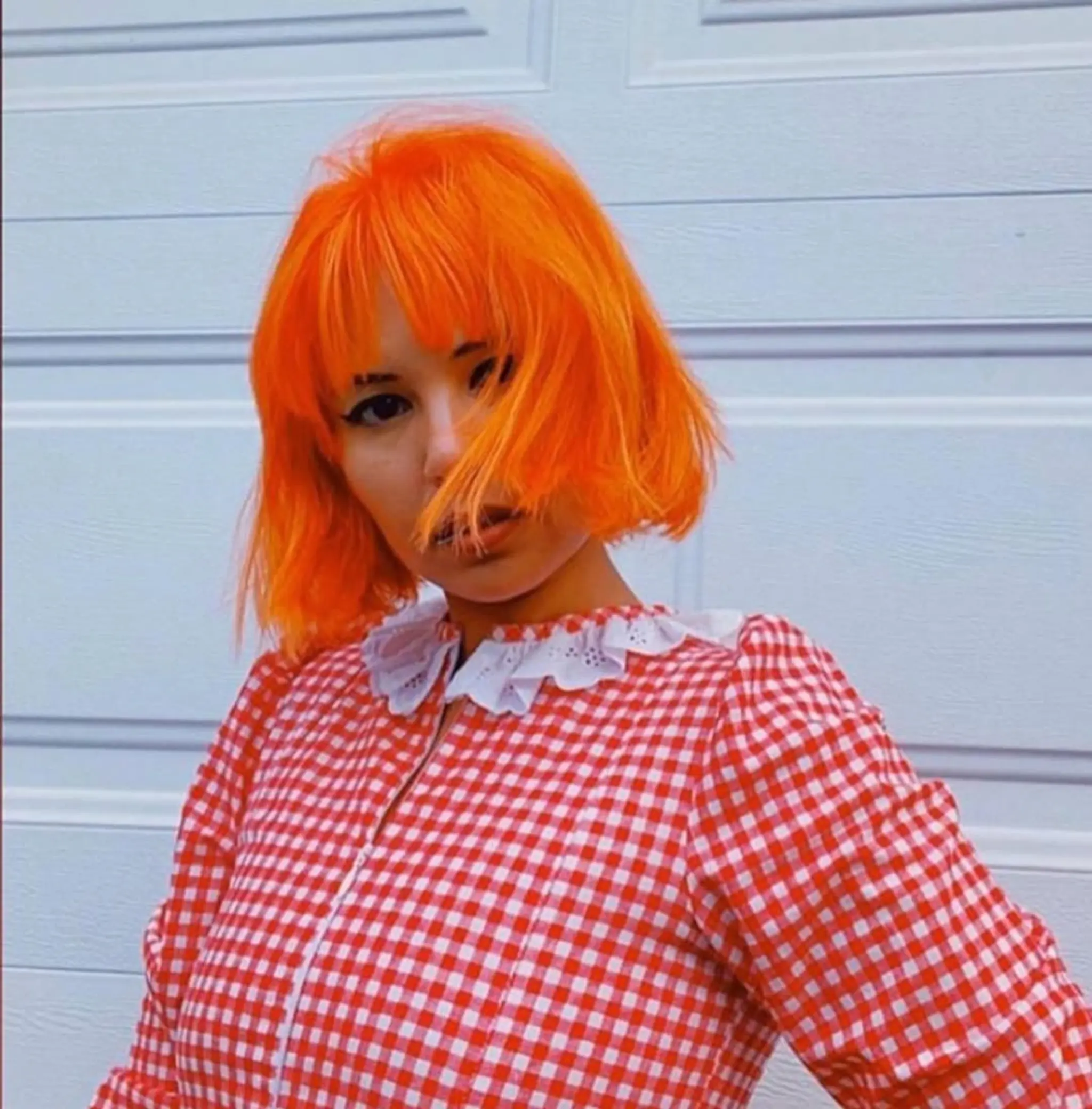 A vibrant orange bob with bangs, perfect for spring and summer.