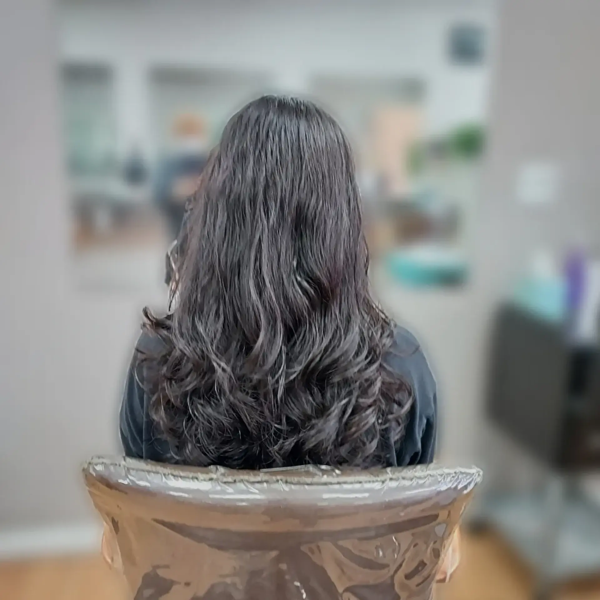 Mid-back length layered dark hair featuring soft, bouncy digital perm waves. 1
