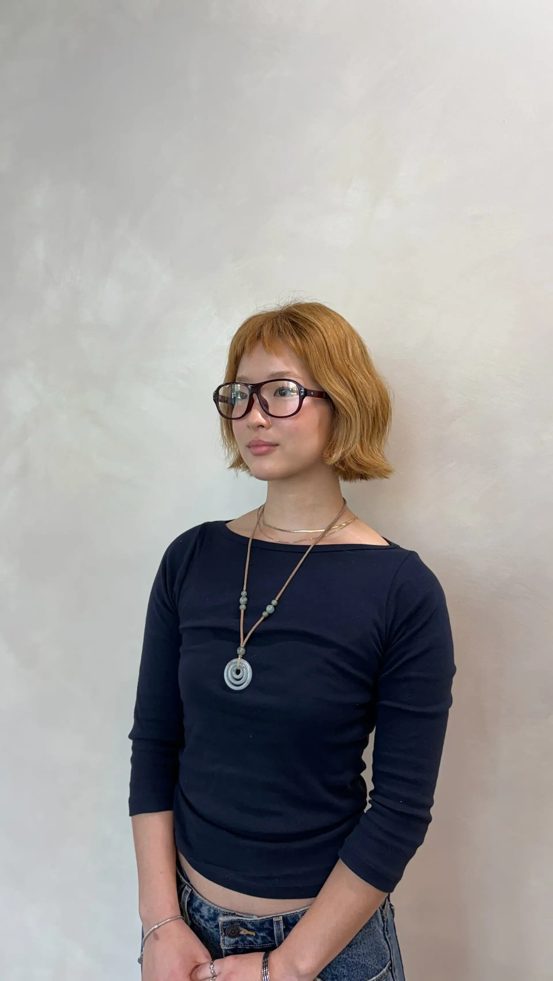 A textured, chin-length bob cut paired with choppy micro bangs and subtle natural wave, styled in a warm golden-copper tone. 1