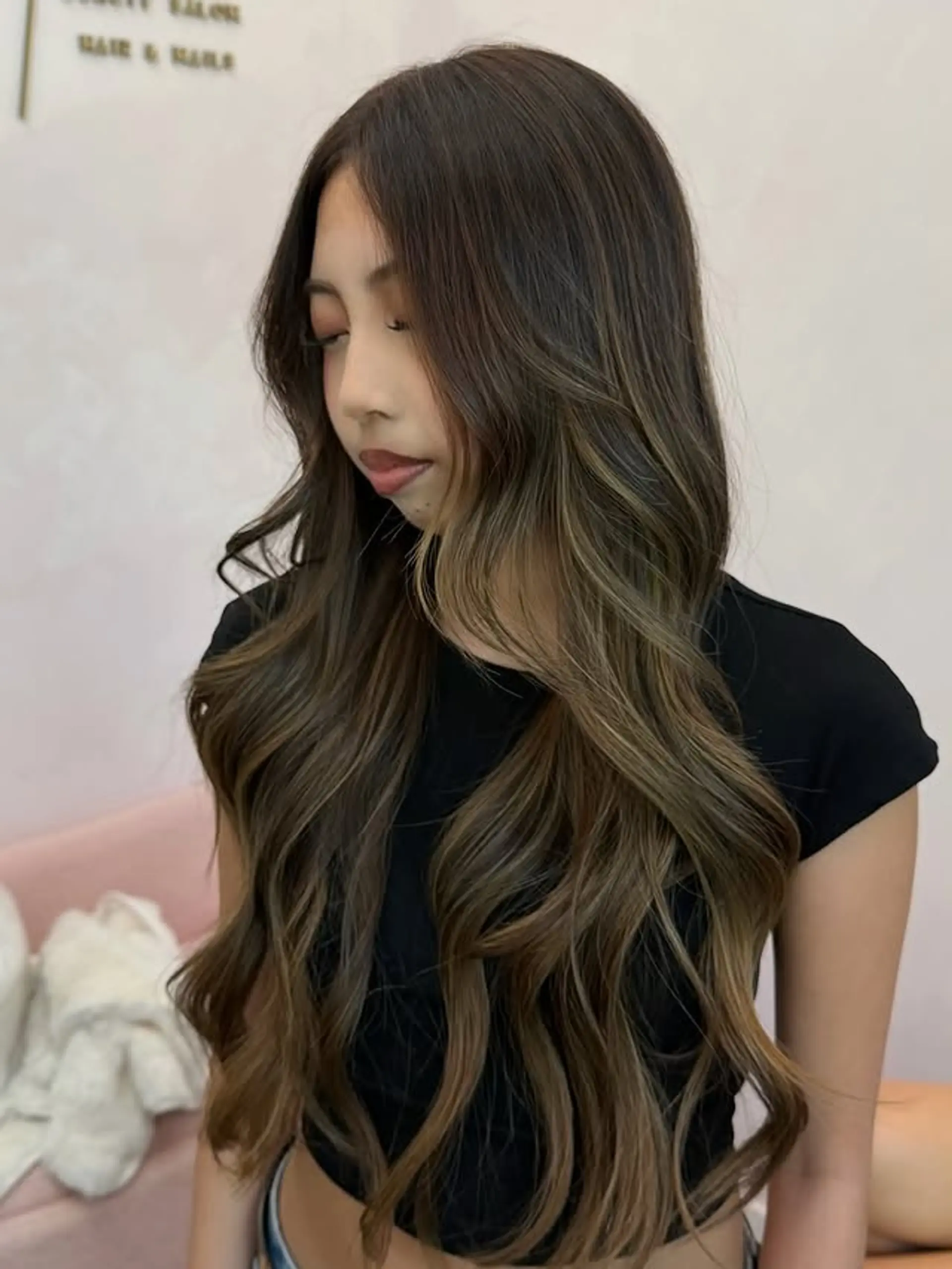 Long, wavy hair with a subtle caramel ash balayage effect, complemented by face-framing layers for added movement and dimension. 1