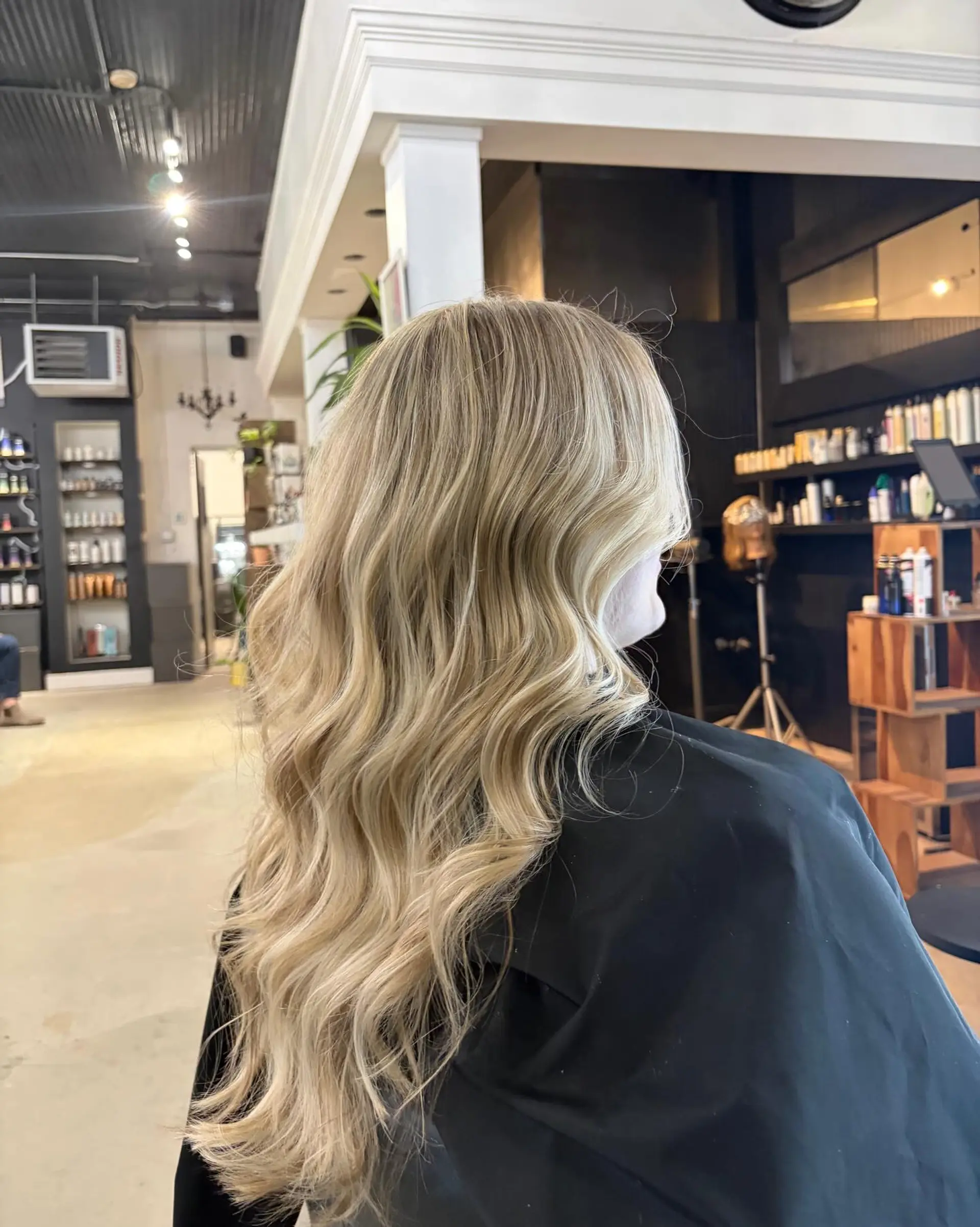 Long dimensional blonde hair styled into soft, elegant waves. 1