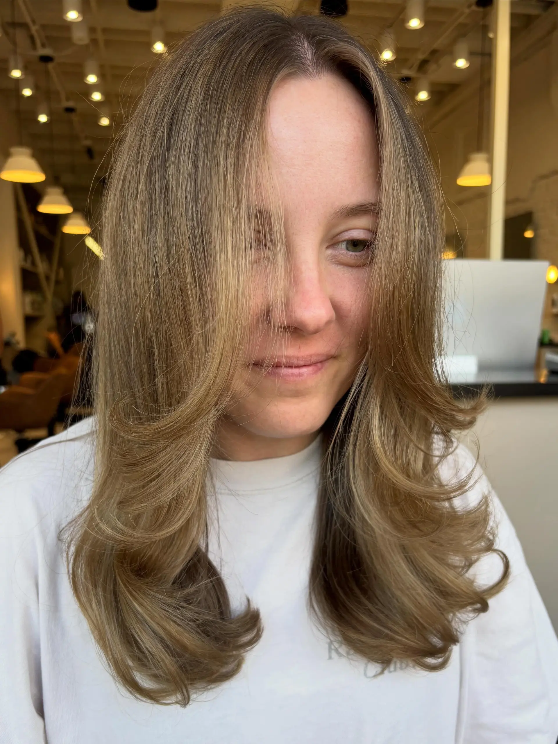 A dimensional bronde color featuring face-framing layers and a bouncy, voluminous blowout with flipped ends. 1