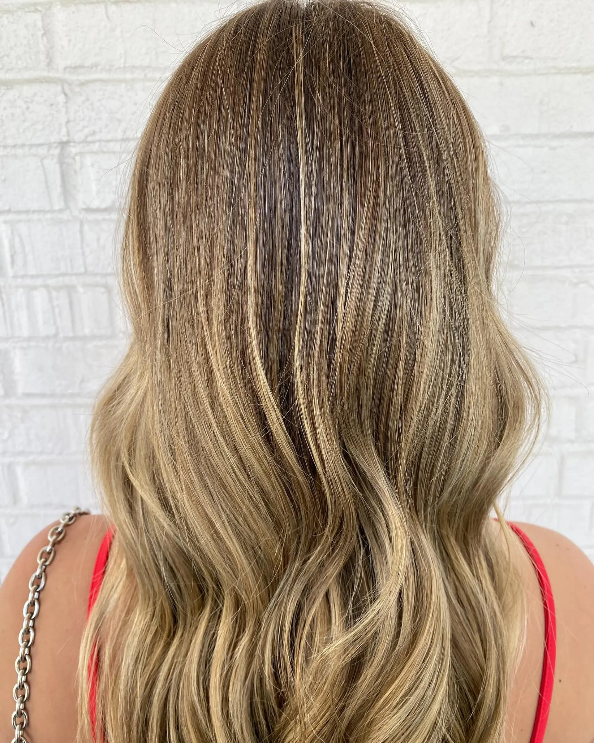 Long buttery blonde balayage with seamless blending and soft, brushed-out waves. 1