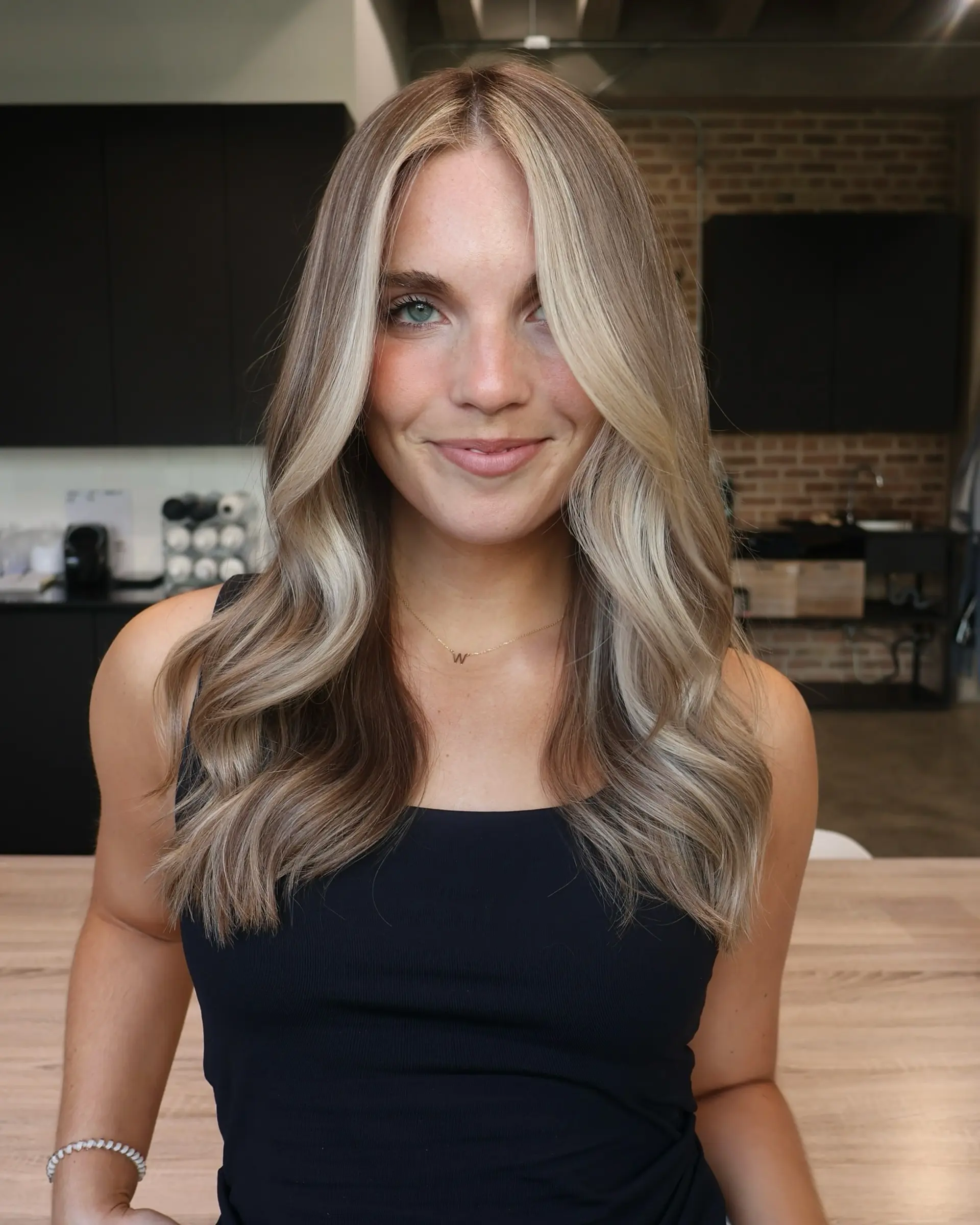 A wavy medium-length style with money piece highlights framing the face. 1