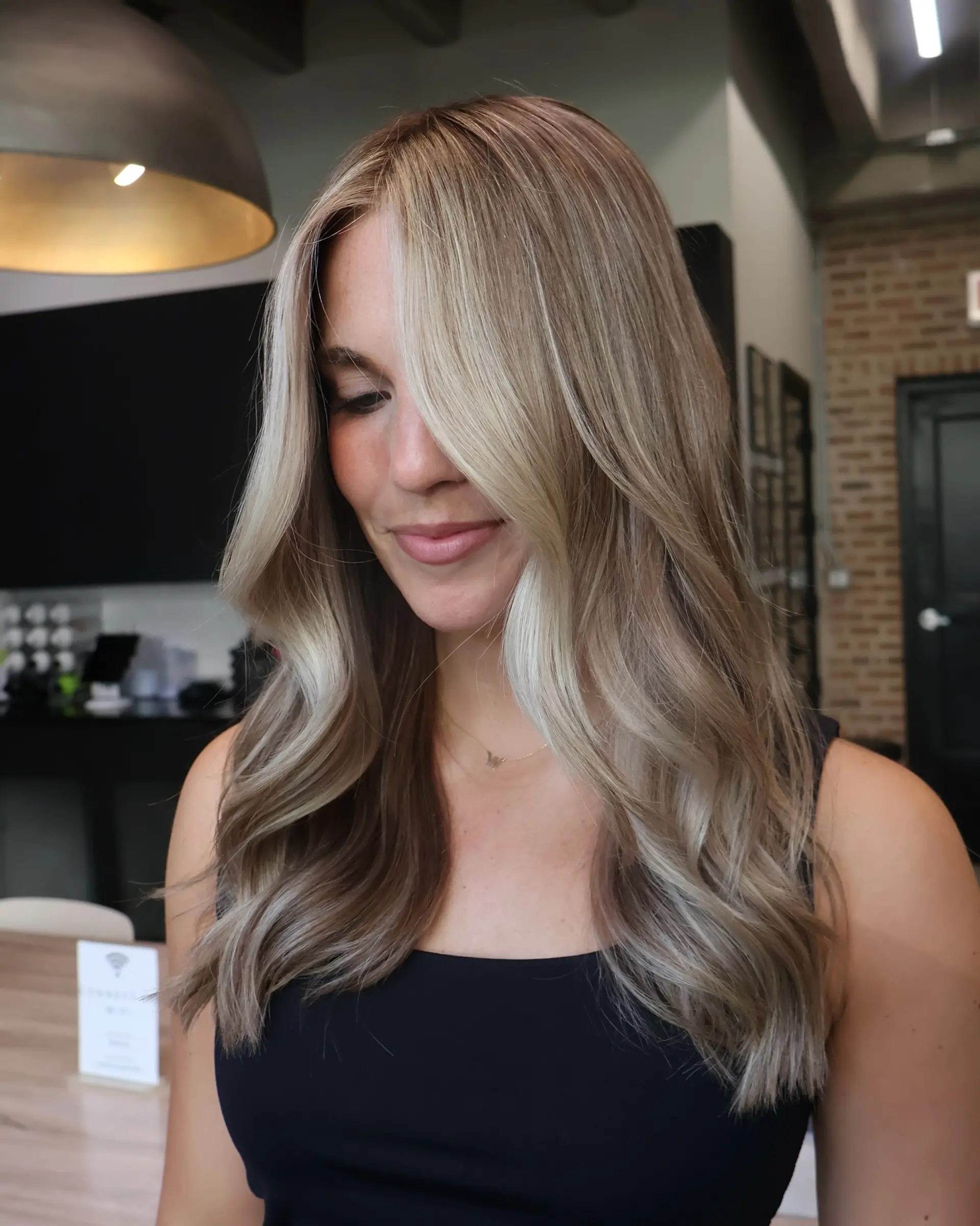 A wavy medium-length style with money piece highlights framing the face. 2