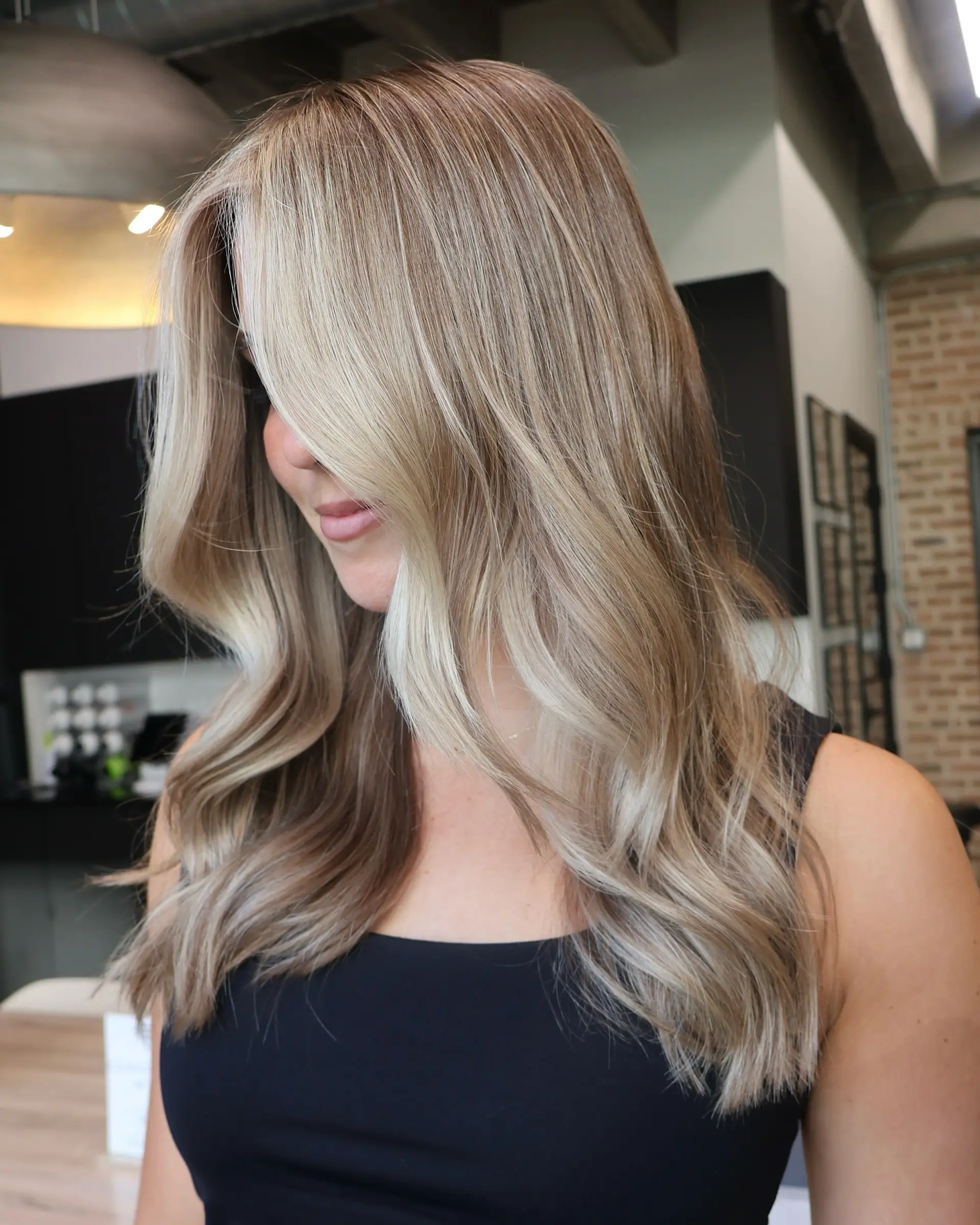 A wavy medium-length style with money piece highlights framing the face. 5