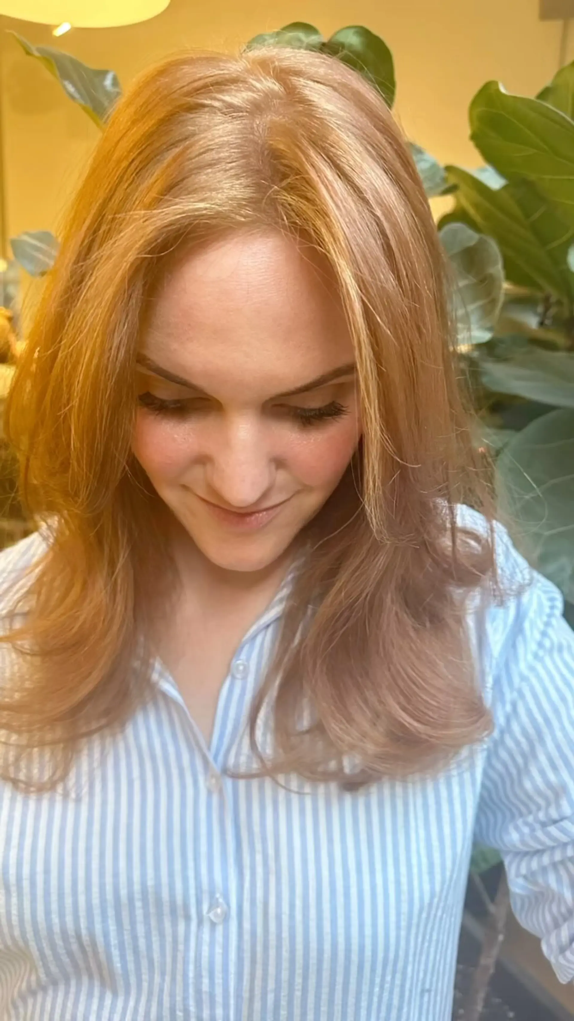 A luminous strawberry blonde and light copper medium-length style with face-framing layers and soft curved ends. 1