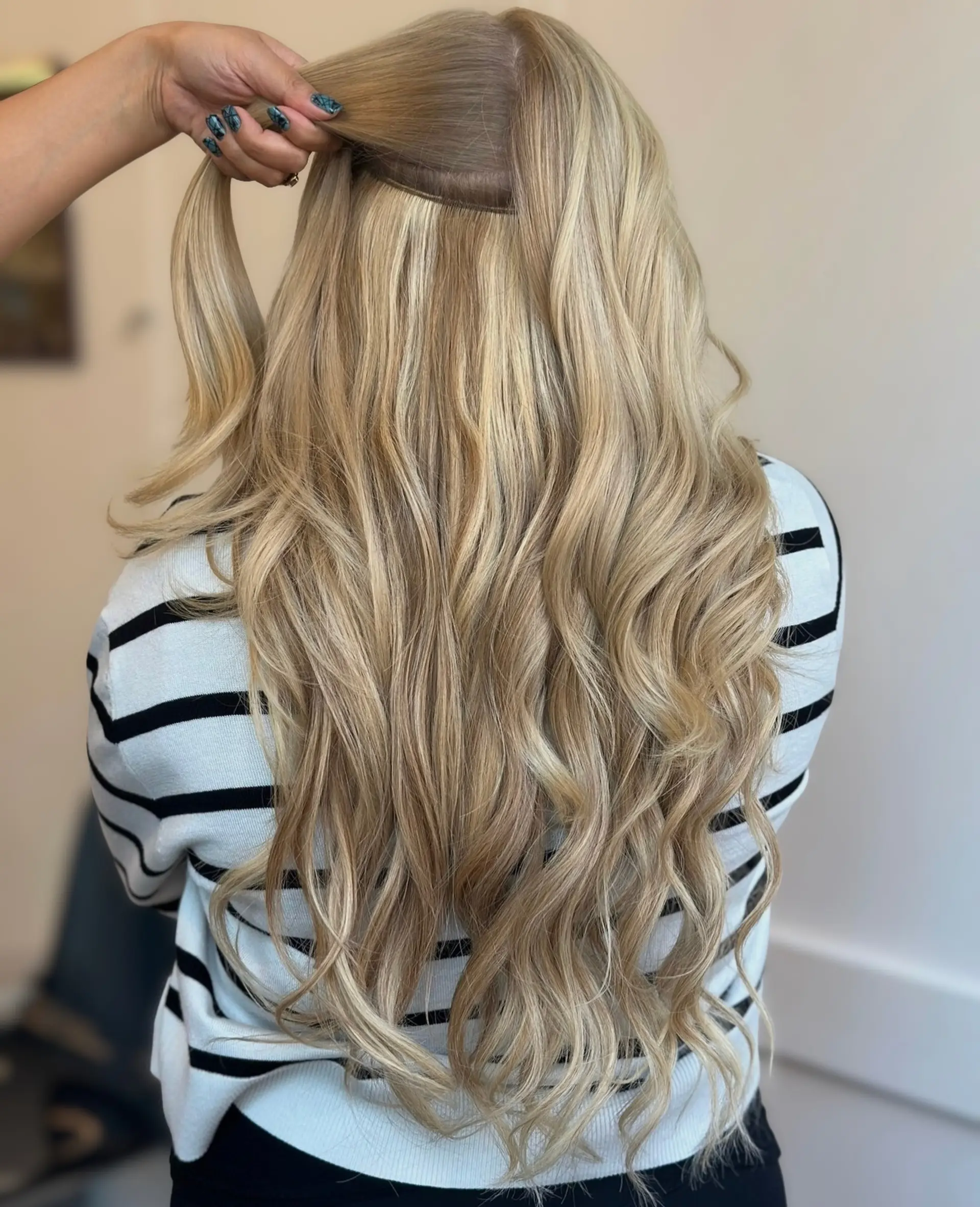 Long blonde wavy hair shown with halo extensions placed seamlessly underneath. 1