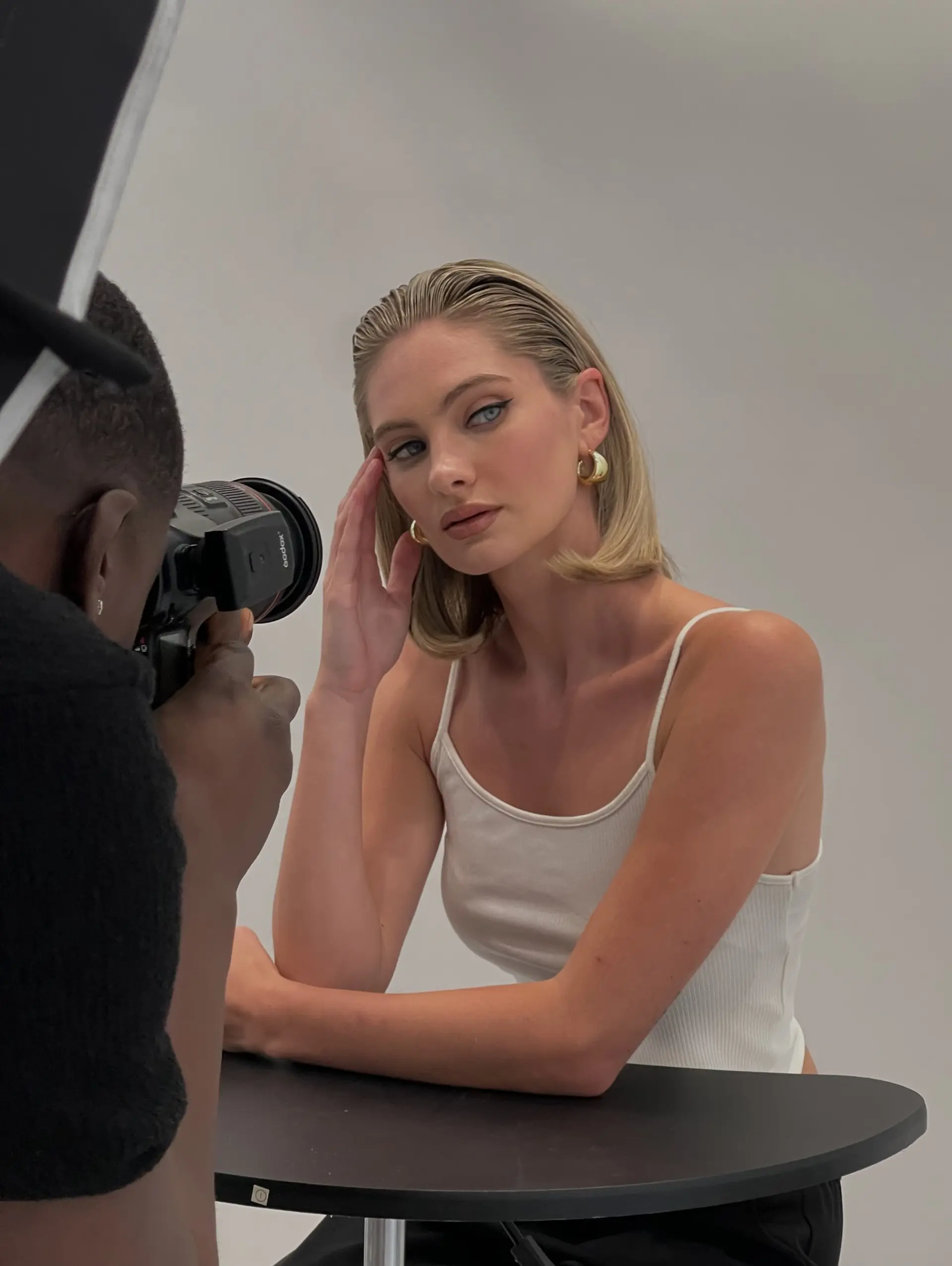 A sleek, editorial wet-look style featuring blonde hair combed straight back with subtle flipped ends. 1