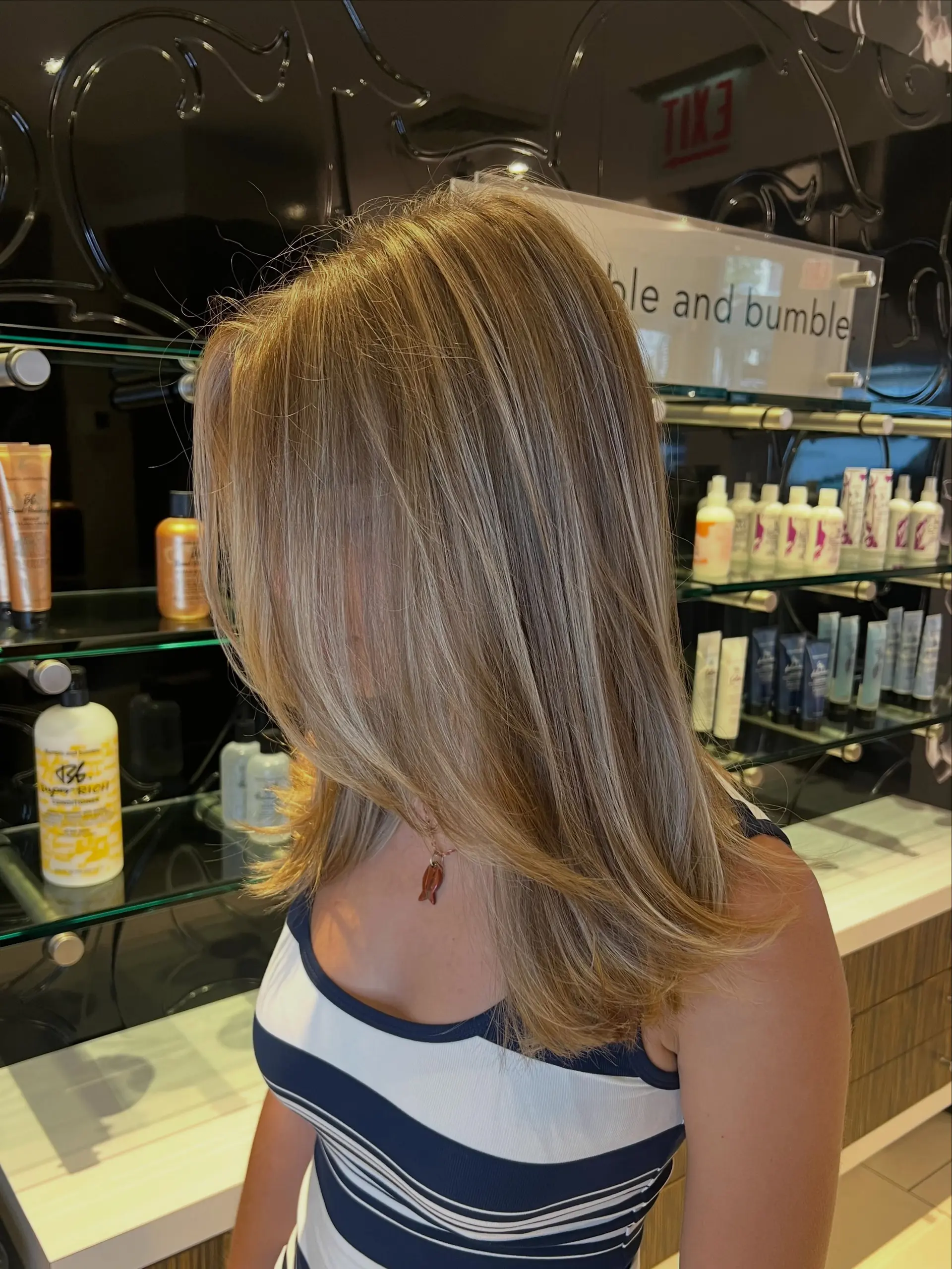 Medium-length straight hair styled with a smooth blowout and soft face-framing layers, featuring seamless lived-in blonde balayage highlights. 1