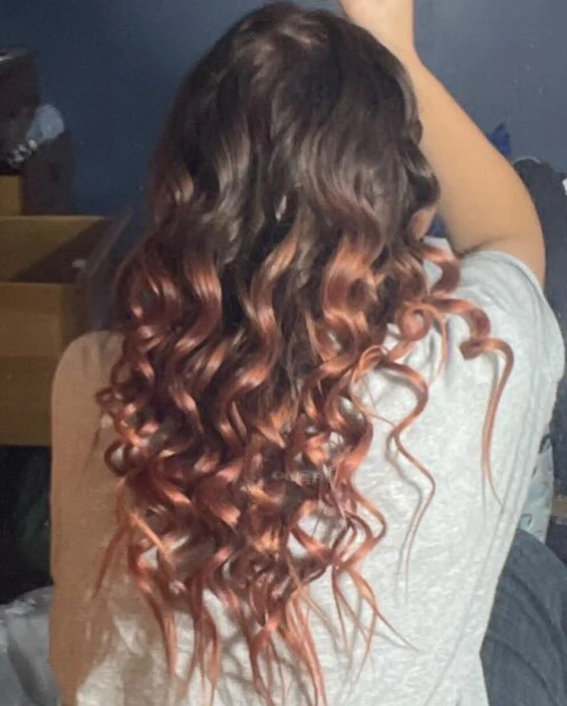 Long dark brown hair transitioning into warm copper tones, styled in defined spiral curls. 1