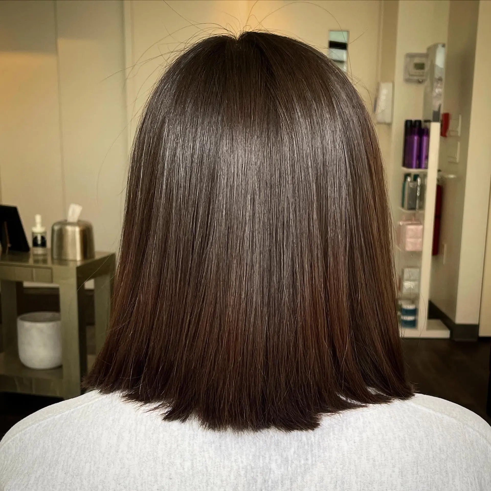 A sleek, straight blunt lob in rich dark brown styled with a glossy, glass-hair finish. 1