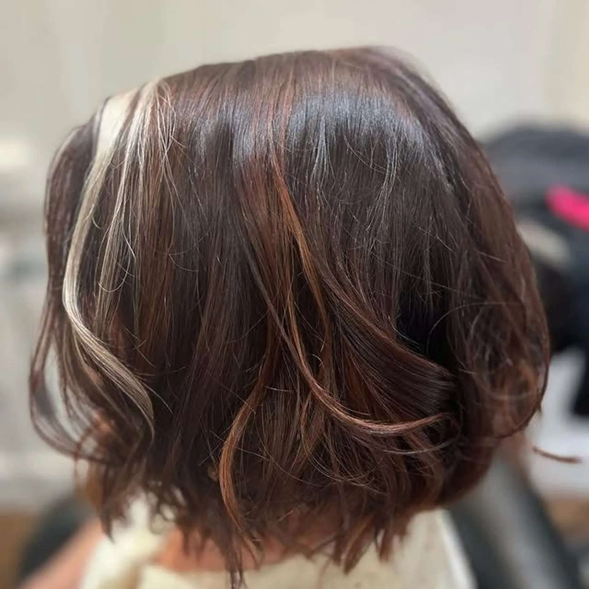 A trendy wavy bob with face-framing money piece highlights. 1