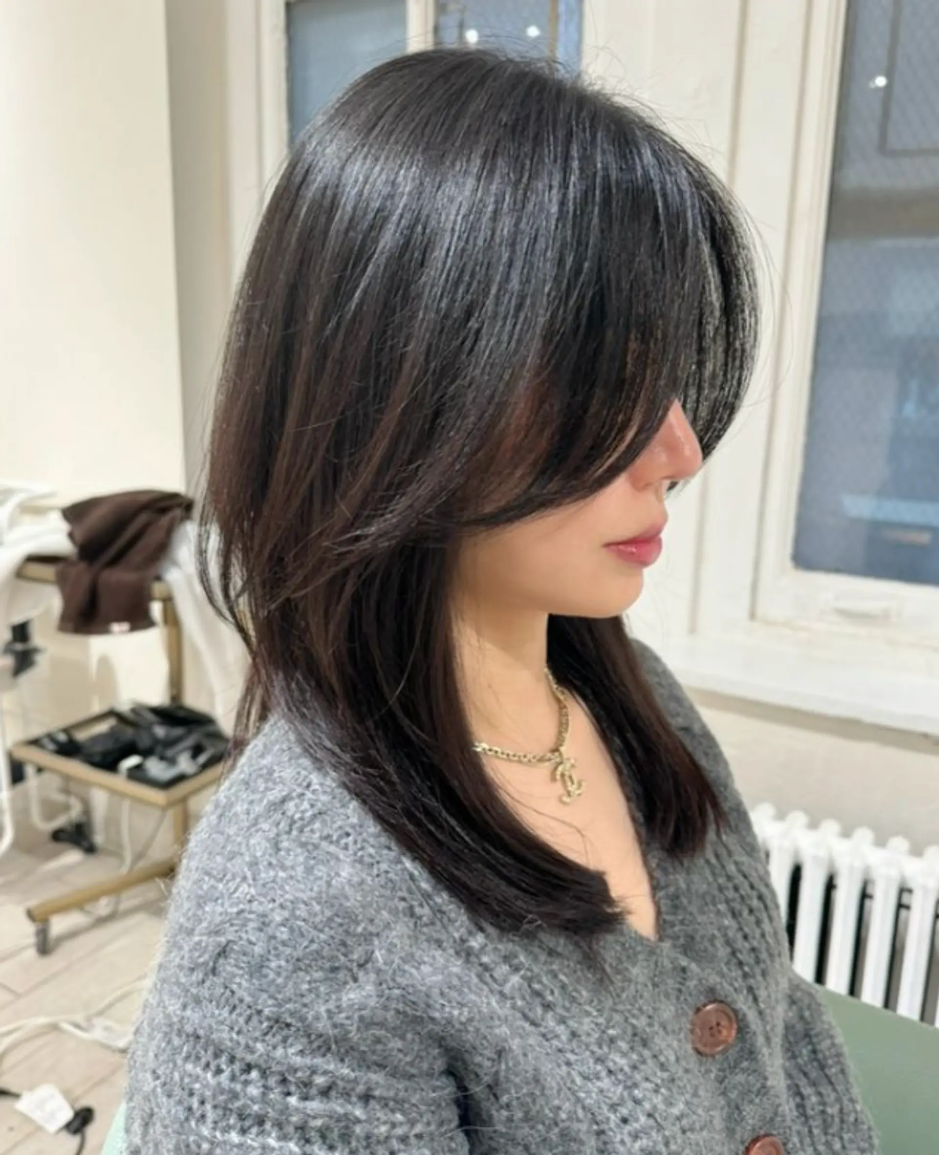 This sleek, medium-length hairstyle features smooth, straight black hair with subtle layers, side bangs, and a glossy finish.

Stylist: @yurihair.newyork 1
