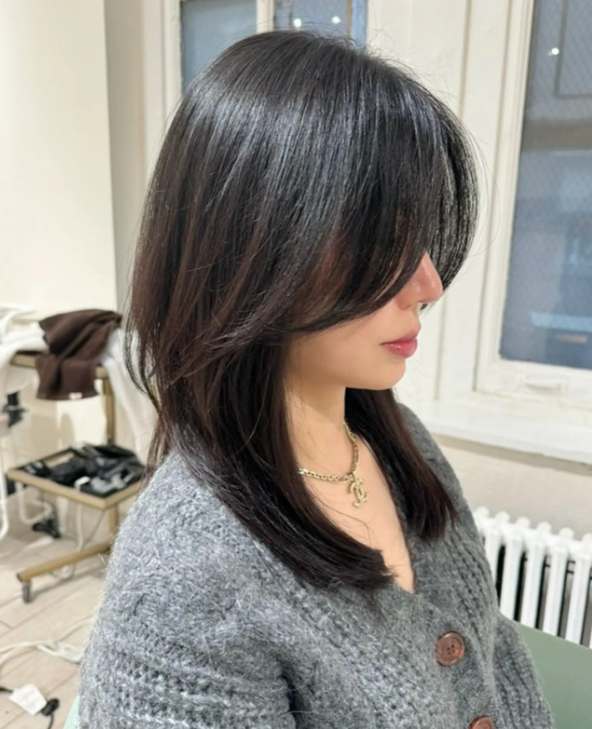 This sleek, medium-length hairstyle features smooth, straight black hair with subtle layers, side bangs, and a glossy finish.

Stylist: @yurihair.newyork