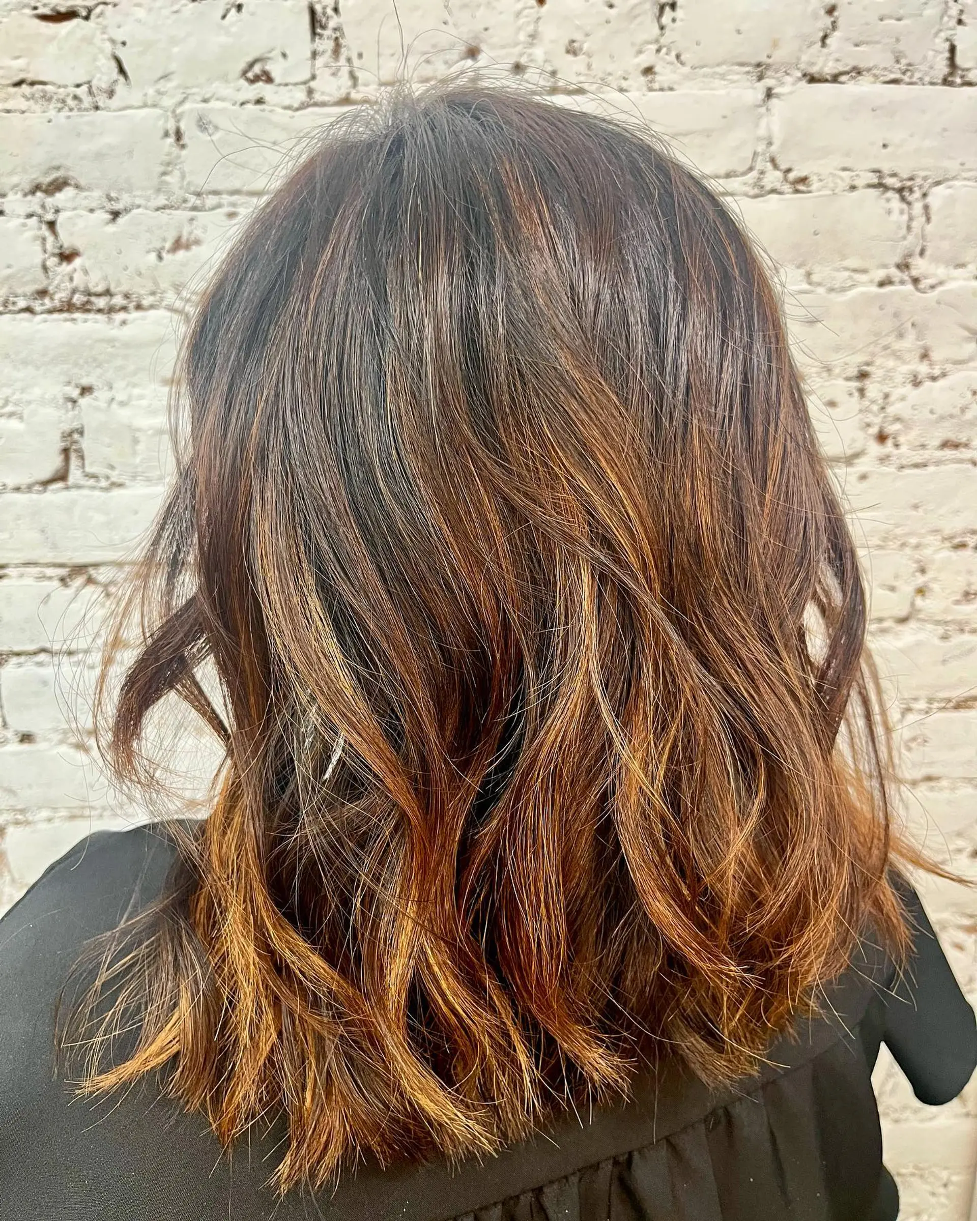Medium-length layered brown hair with warm caramel highlights styled into effortless, piecey waves. 1