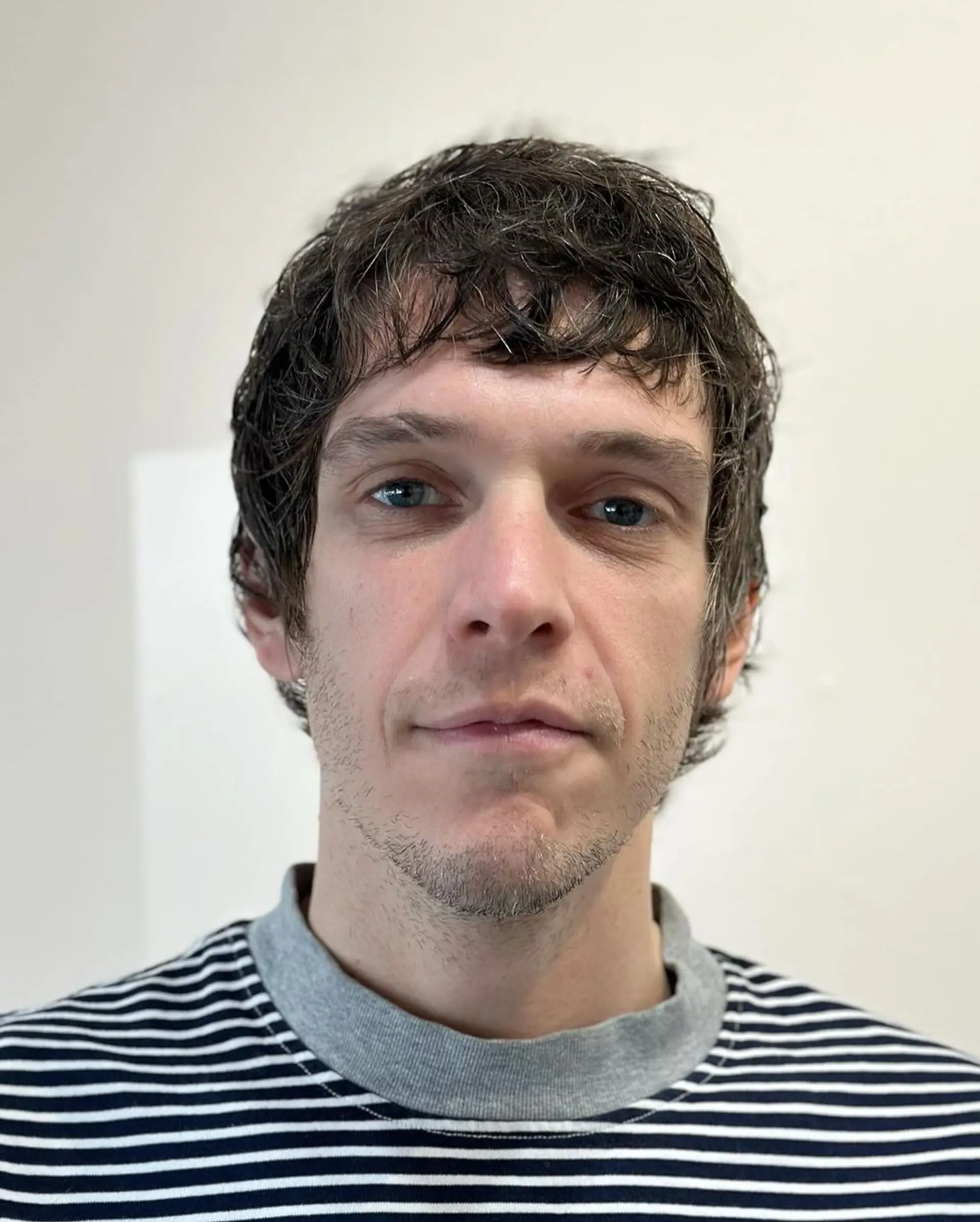 A medium-length, wavy, dark brown hairstyle with textured layers and a side-swept fringe, presenting a casual, tousled appearance. 3