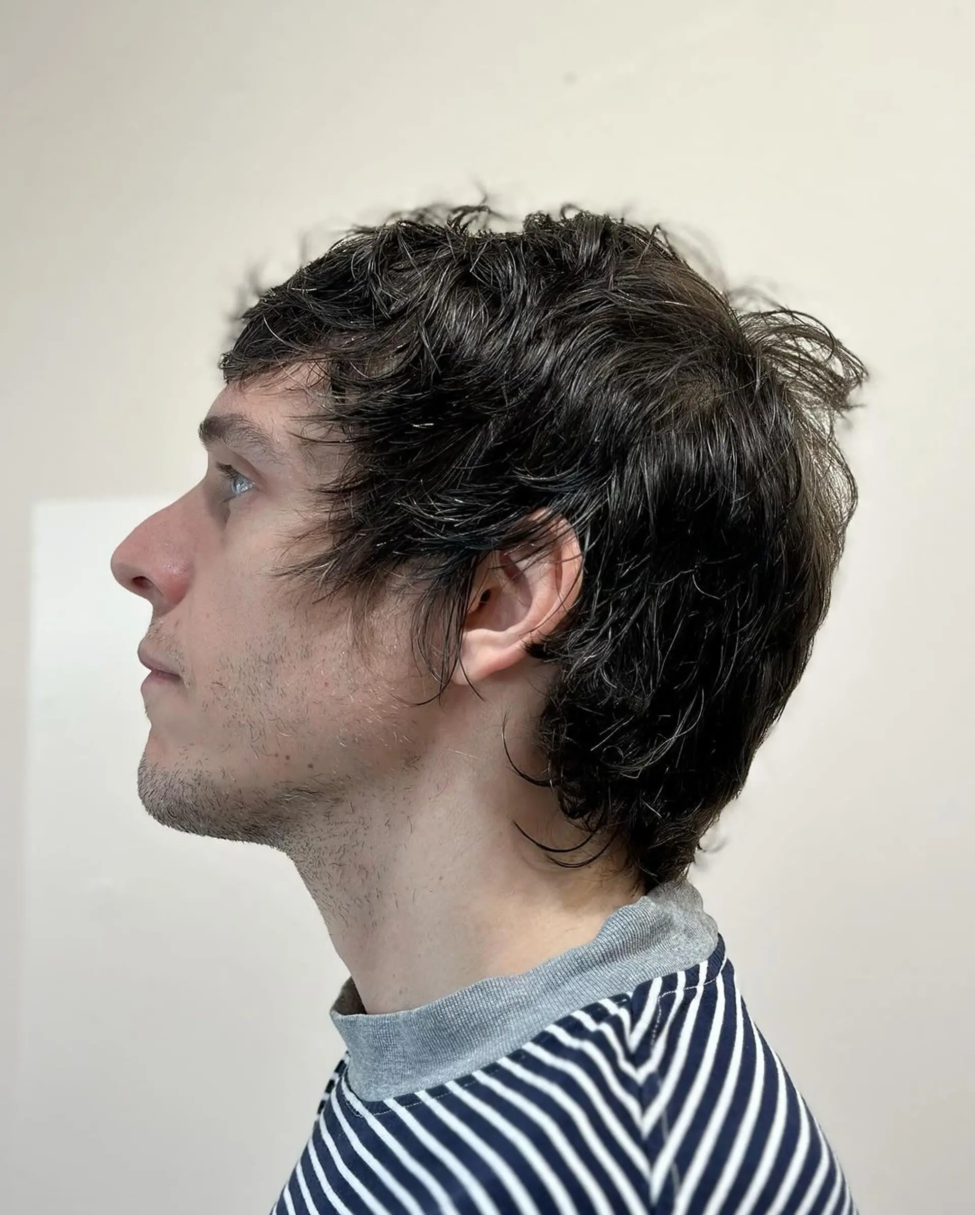 A medium-length, wavy, dark brown hairstyle with textured layers and a side-swept fringe, presenting a casual, tousled appearance. 2